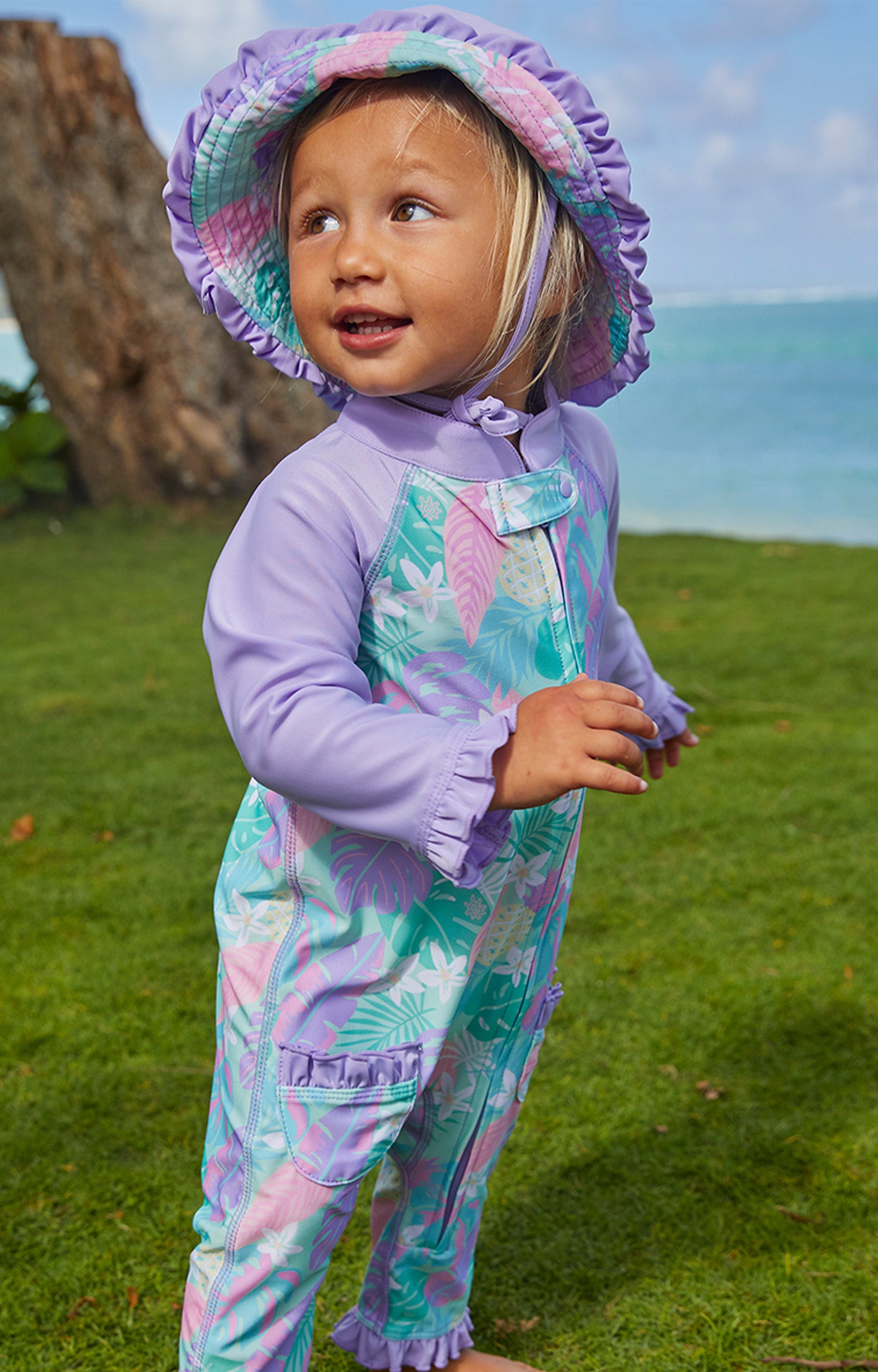 Little girl wearing UV Skinz's baby girl's reversible sun hat in hidden pineapples|hidden-pineapples