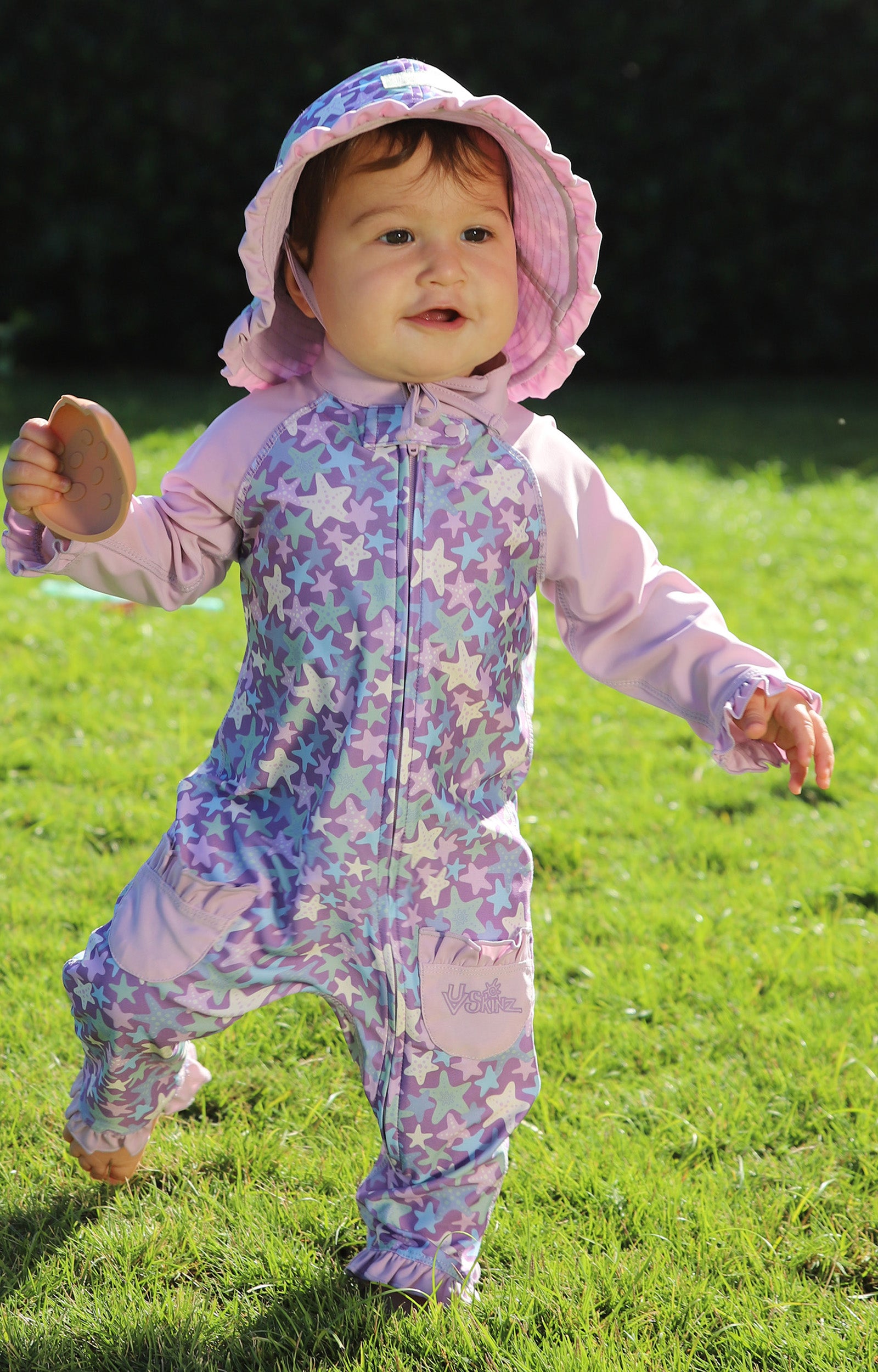 baby girl running in field in one piece sun & swim suit in lotus-starfish|lotus-starfish