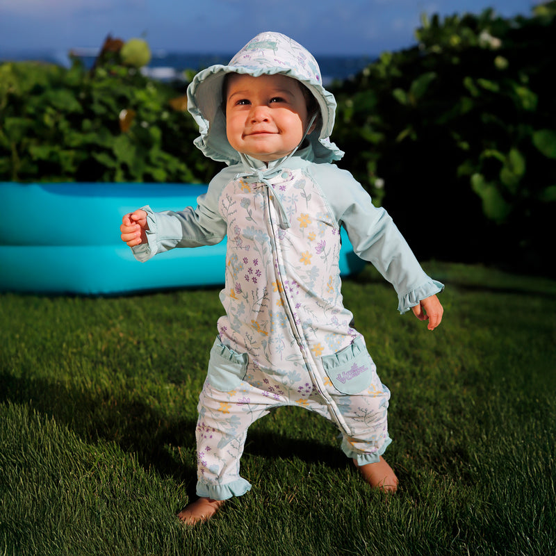 baby girl running in grass in one piece sun & swim suit in springtime doodle|springtime-doodle