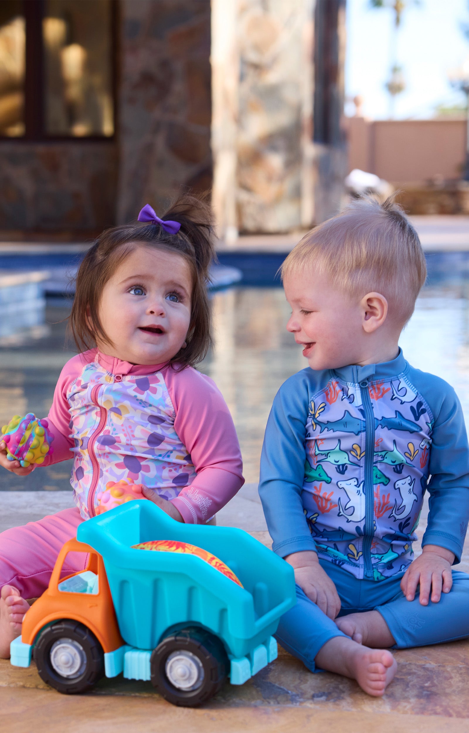 baby girl baby boy playing by pool with toys in swim leggingz|baltic-reef-shark