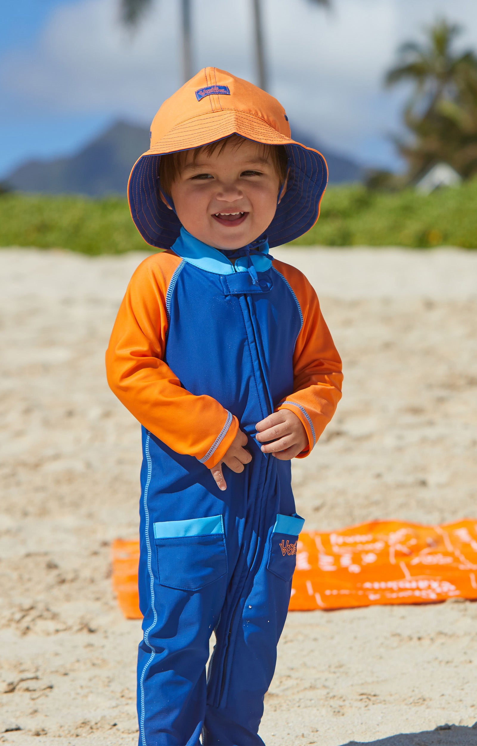 Baby boy in UV Skinz's  baby boy's long-sleeve swimsuit in navy blue orange|navy-blue-orange