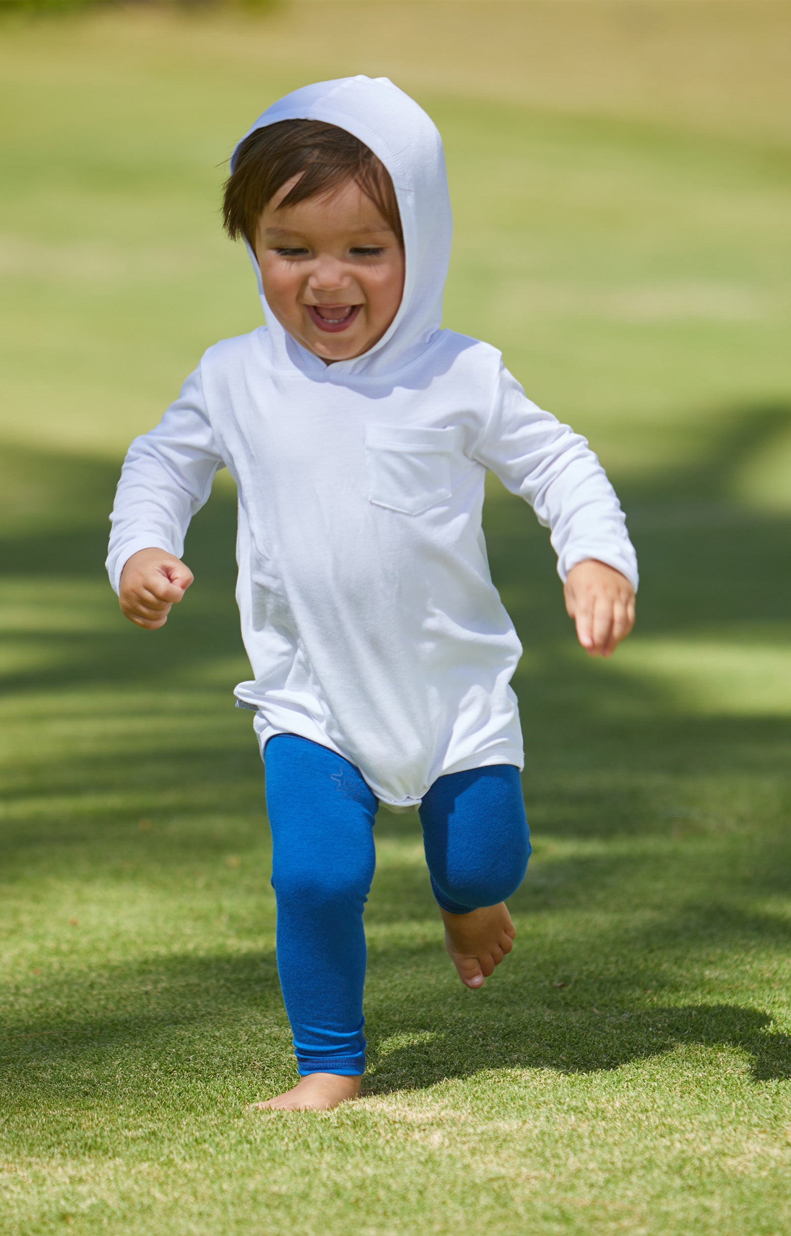 Baby Boy Running in the Grass in the Baby Boy's Hooded Sunzie in White|white