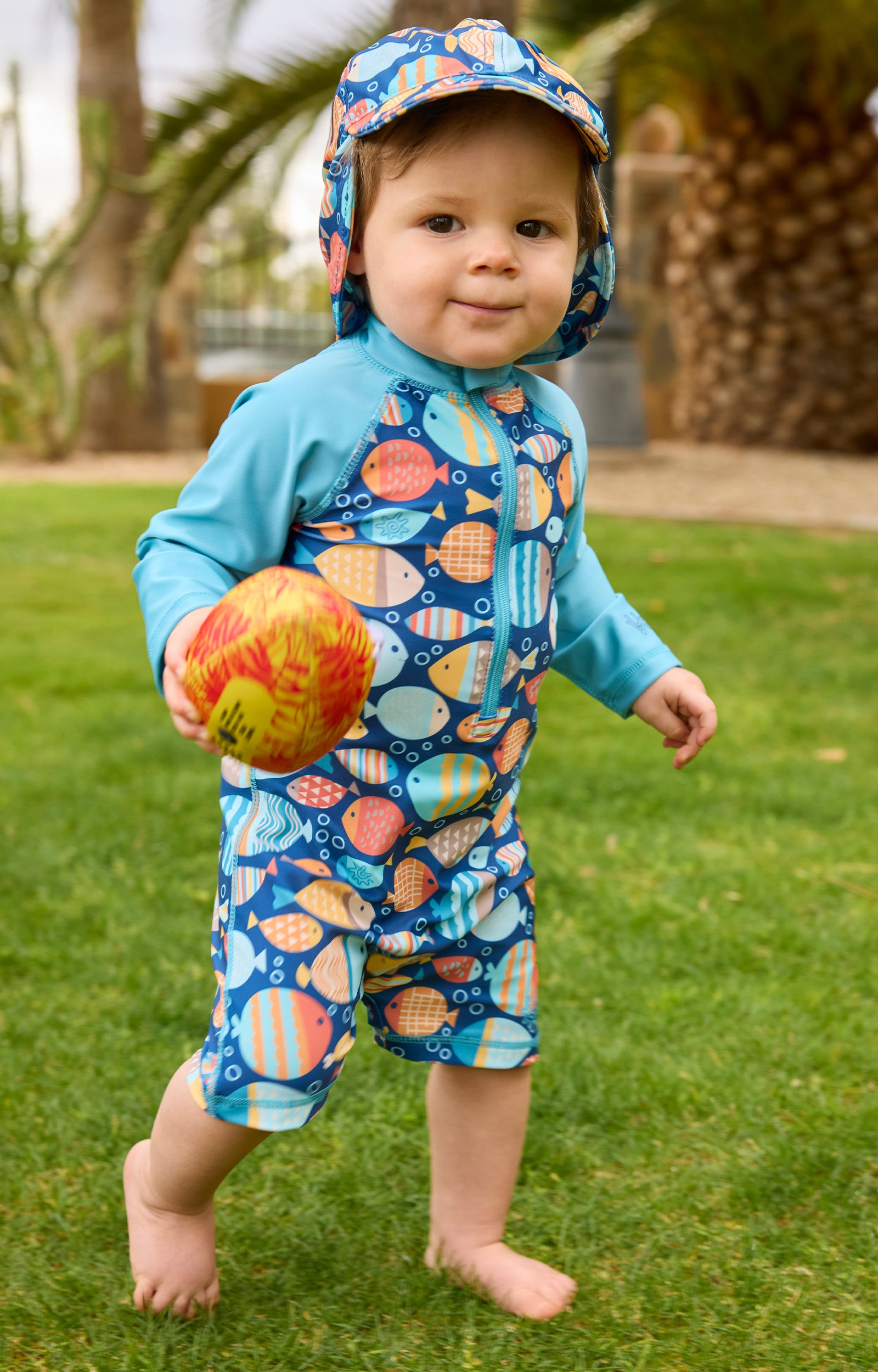 baby boy running in grass in long sleeve swim romper|fish-parade