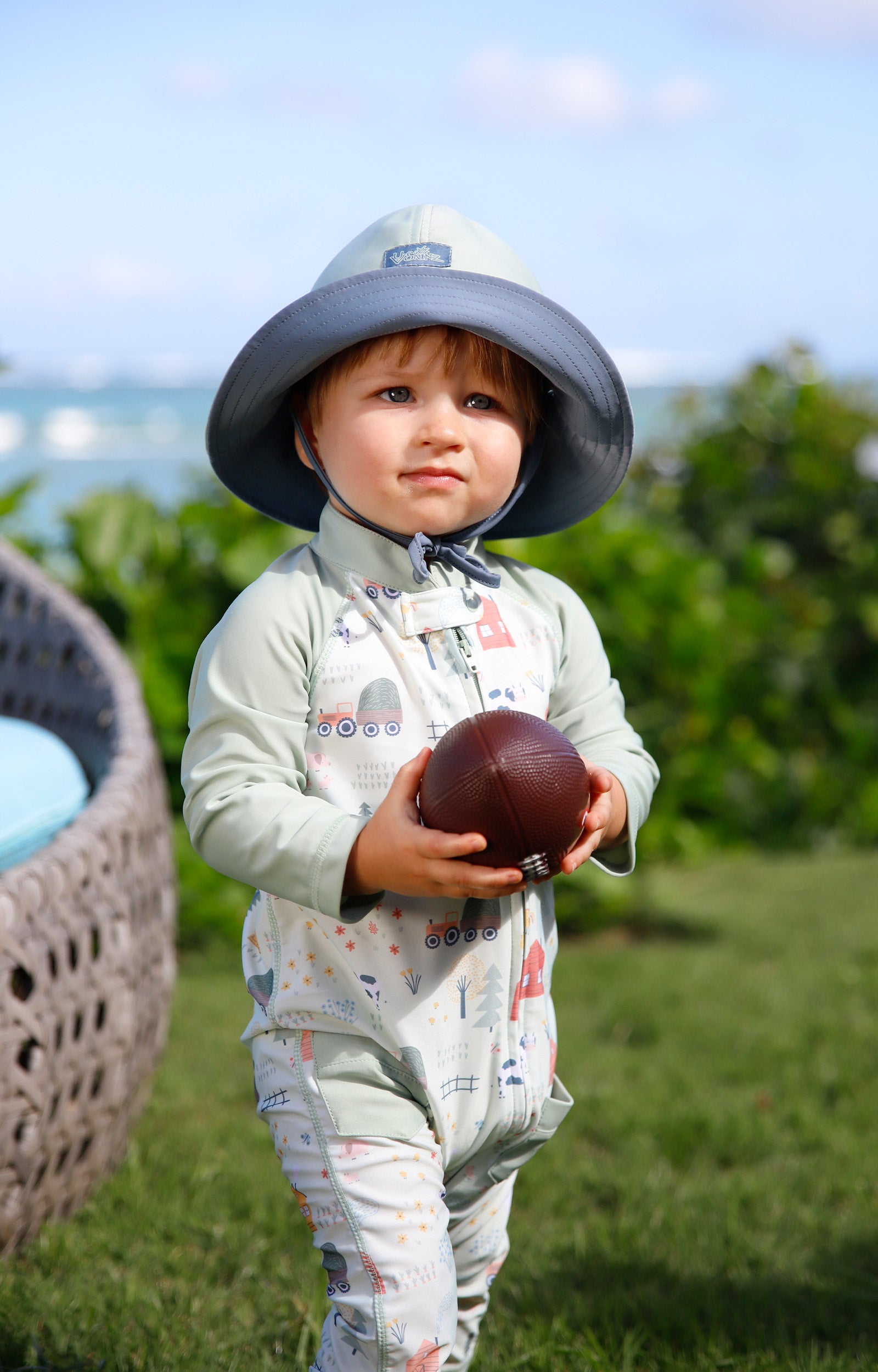 baby in grass in reversible sun hat in frosty green mirage|frosty-green-mirage