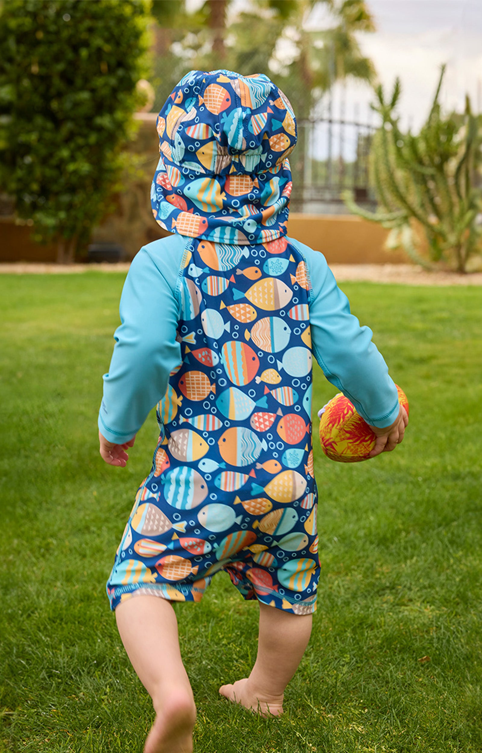baby boy running away in swim flap hat|fish-parade
