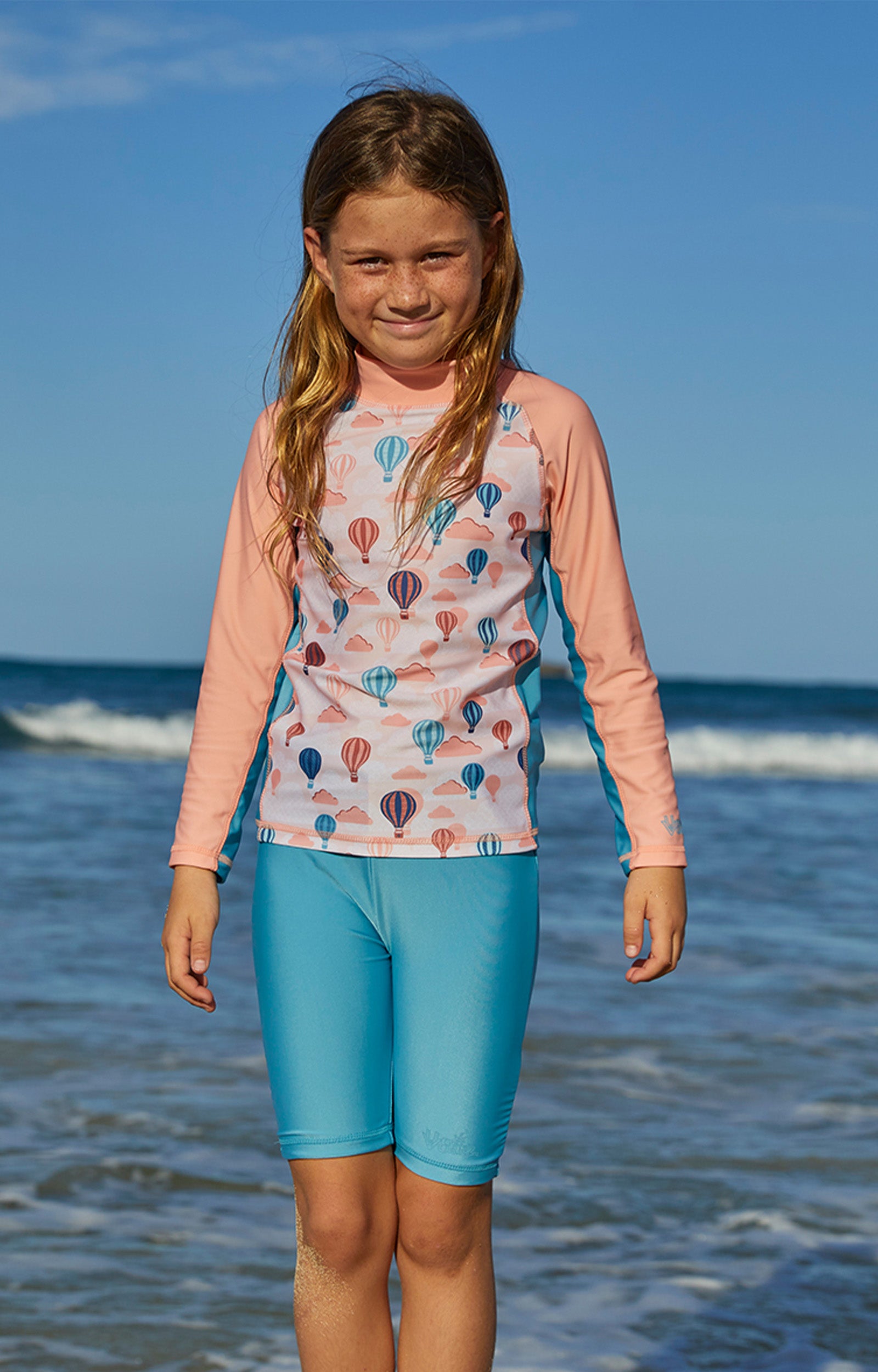 Girl in the ocean in UV Skinz's girl's swim shorts in lagoon|lagoon