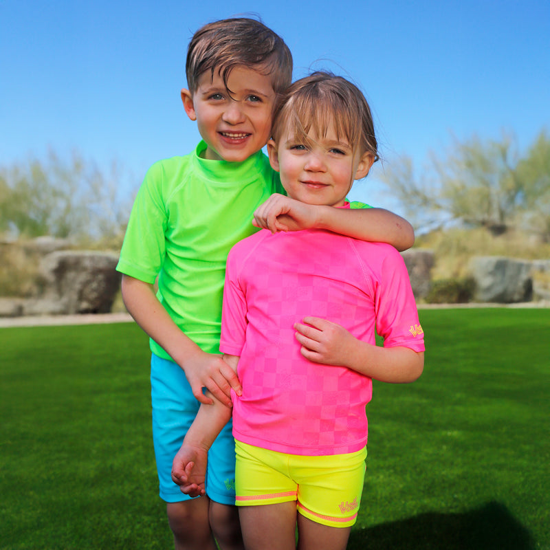 girl having fun in grass with girls neon reversible active swim shorts in neon yellow|neon-sorbet-neon-yellow