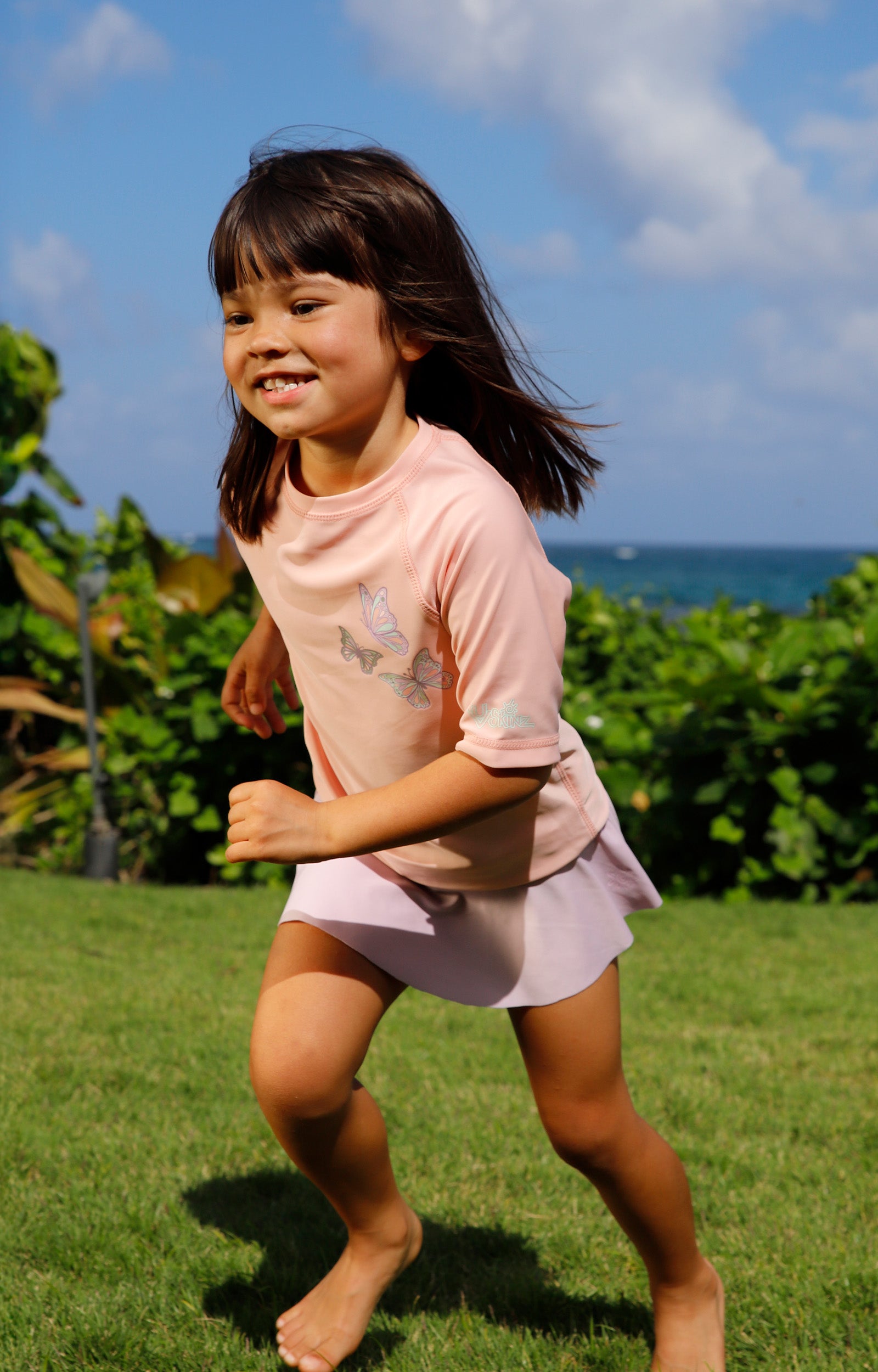 girl running in kids short sleeve crew sunny swim shirt in butterfly besties|butterfly-besties