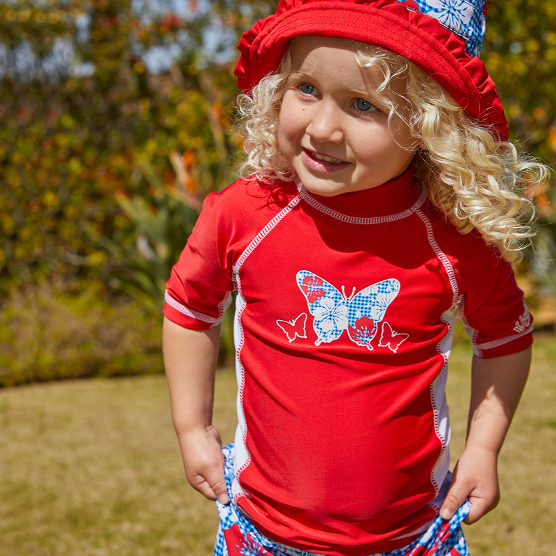Little girl in UV Skinz's girl's short sleeve sunny swim shirt in americana butterfly|americana-butterfly