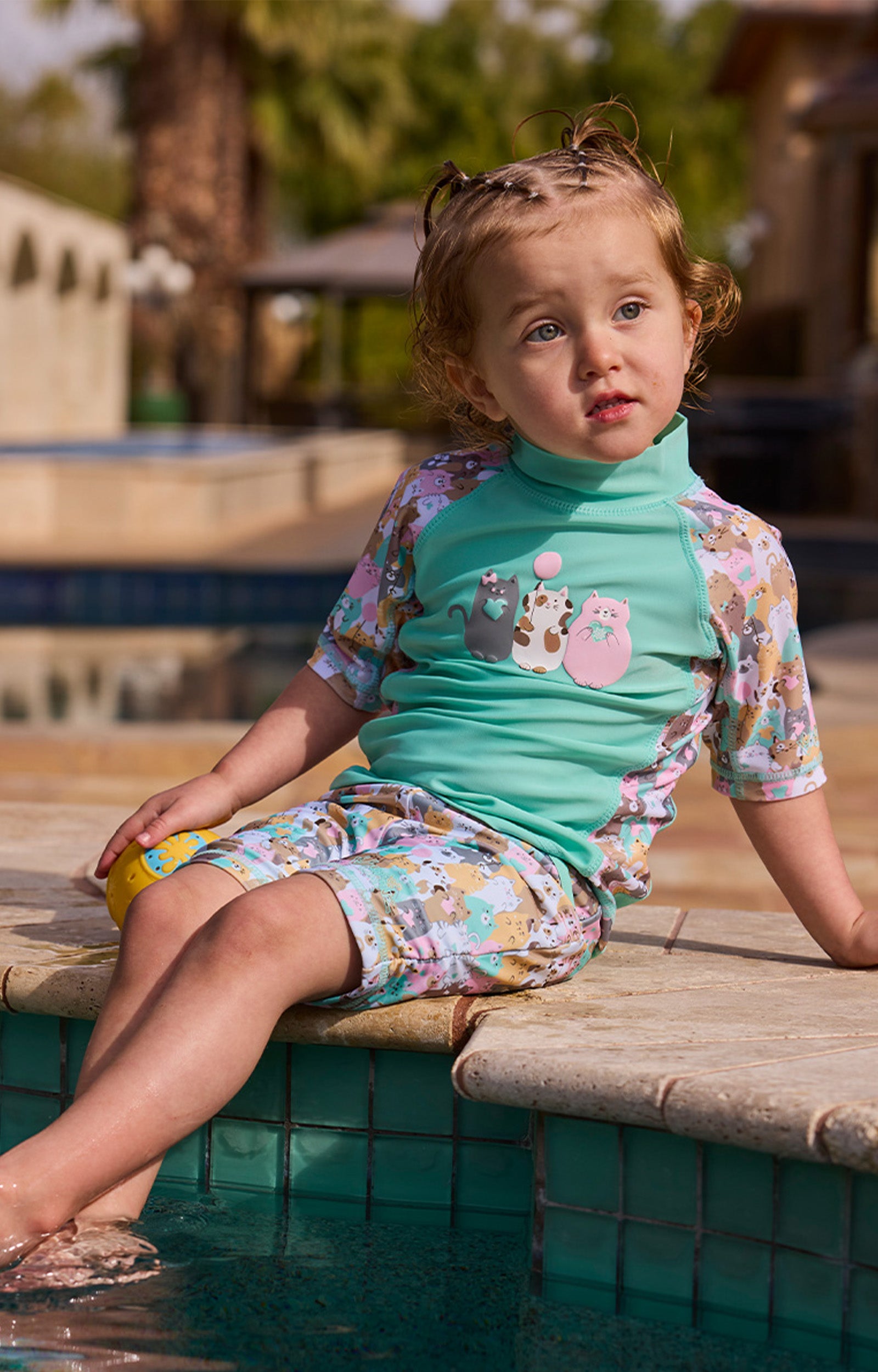 girl in short sleeve sunny swim shirt with feet in the pool|purr-fect-parade