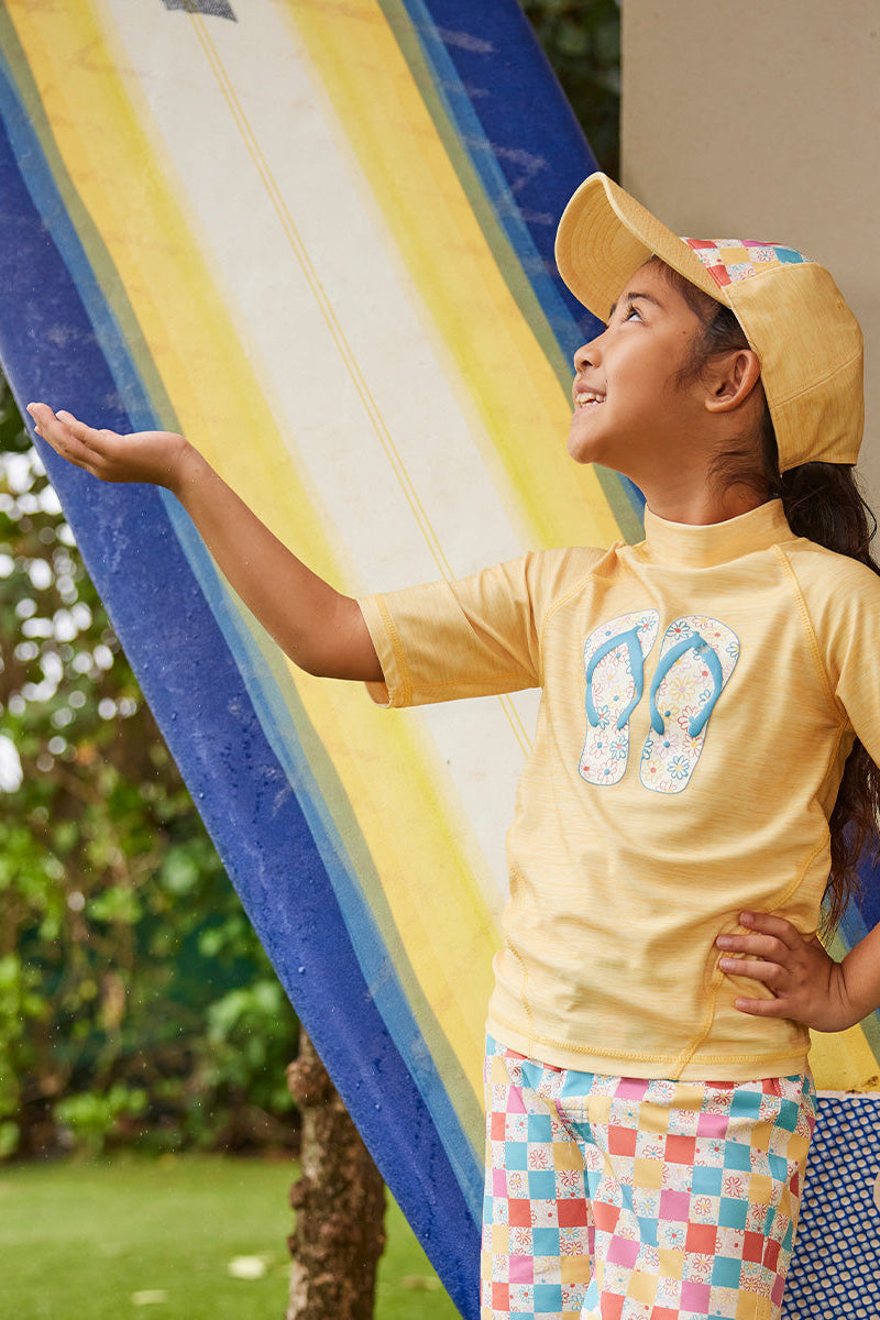 girl by surfboard in short sleeve sport sun & swim shirt|marigold-sandy-beach