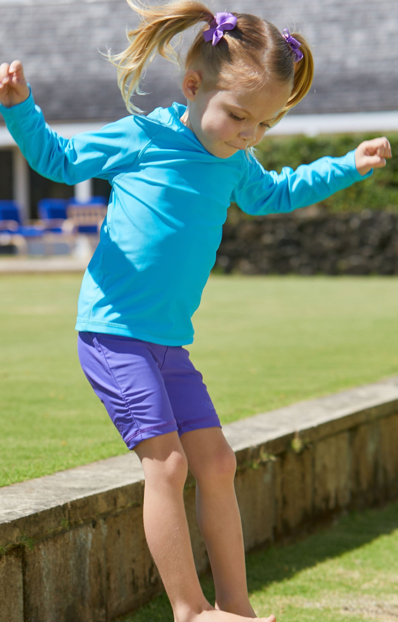 Little girl playing in UV Skinz's purple swim shorts|purple