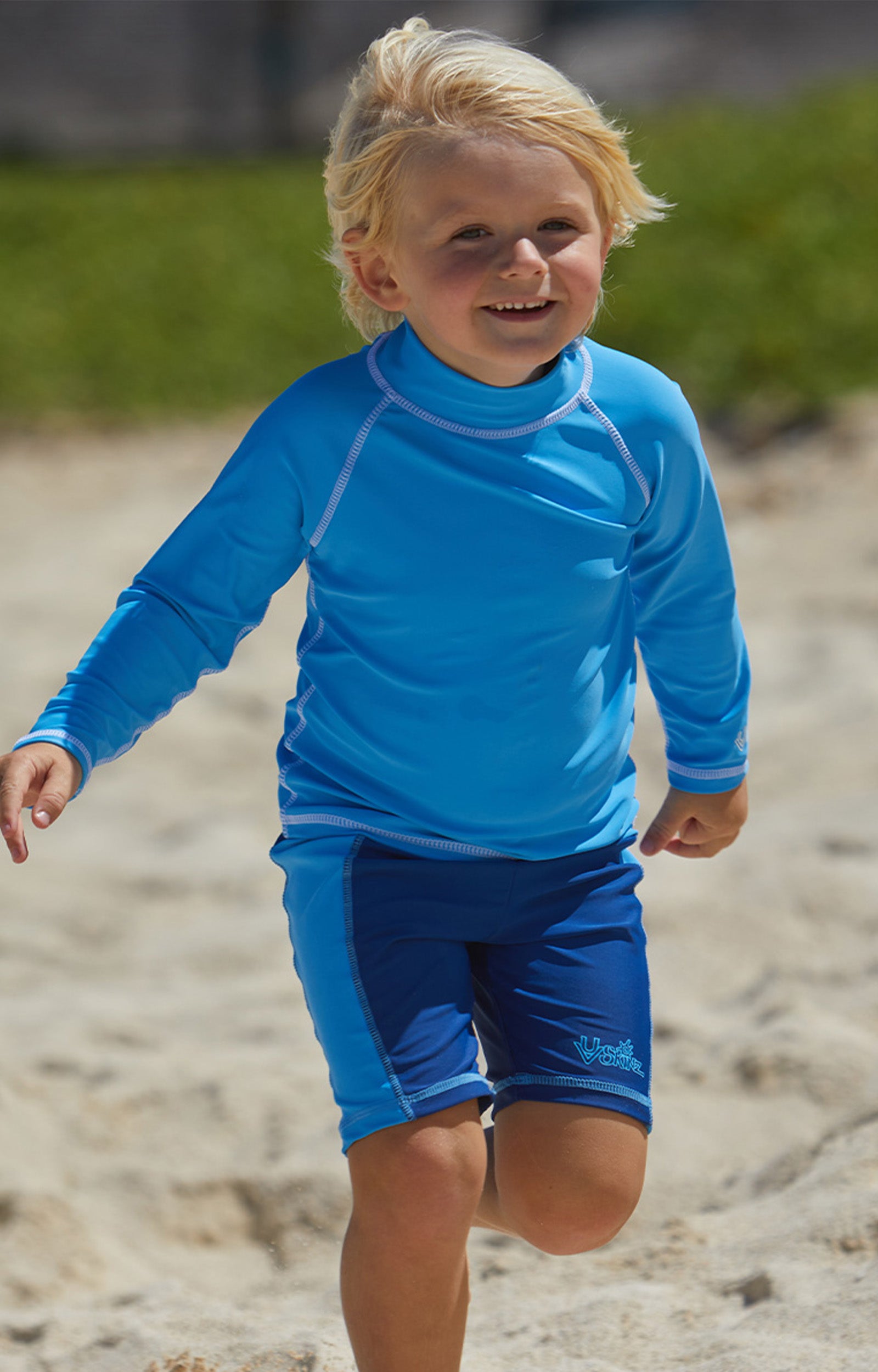 Little boy in UV Skinz's boy's swim shorts in navy ocean blue|navy-ocean-blue