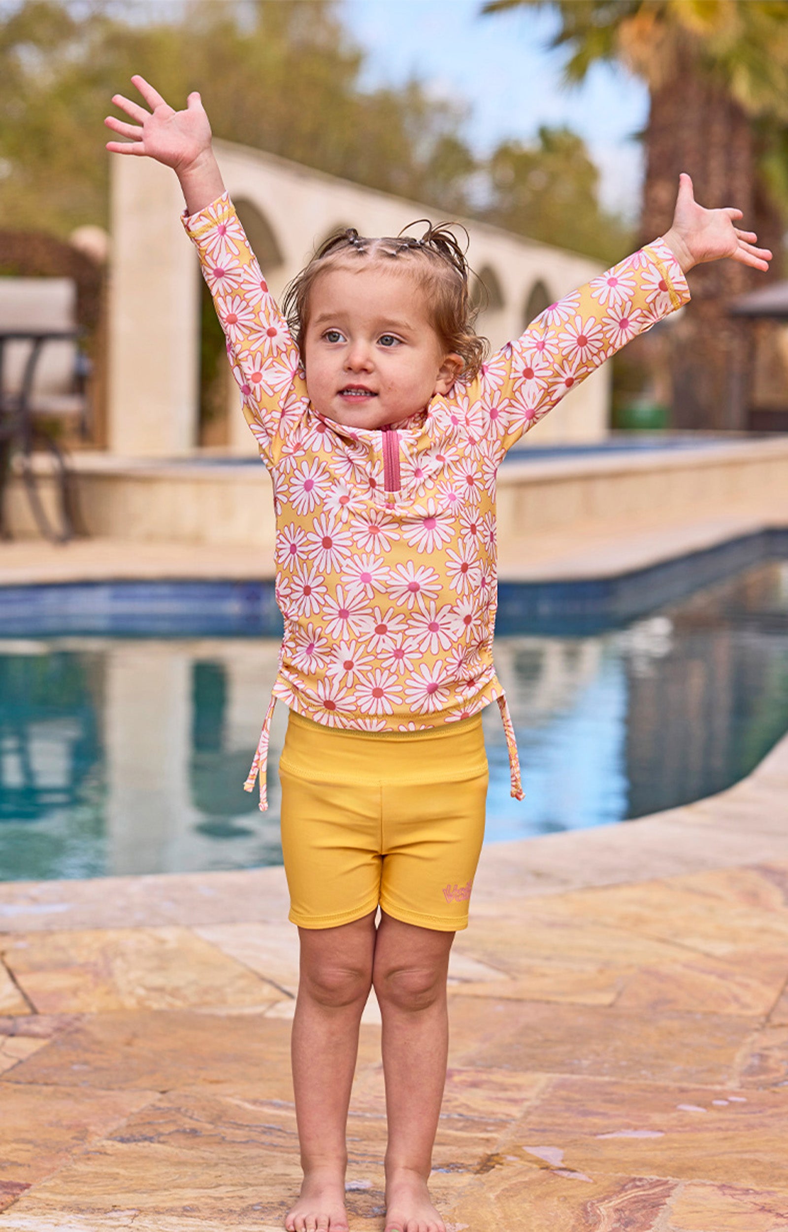 girl with arms up by pool in half zip ruched sun & swim shirt|sunshine-daisies