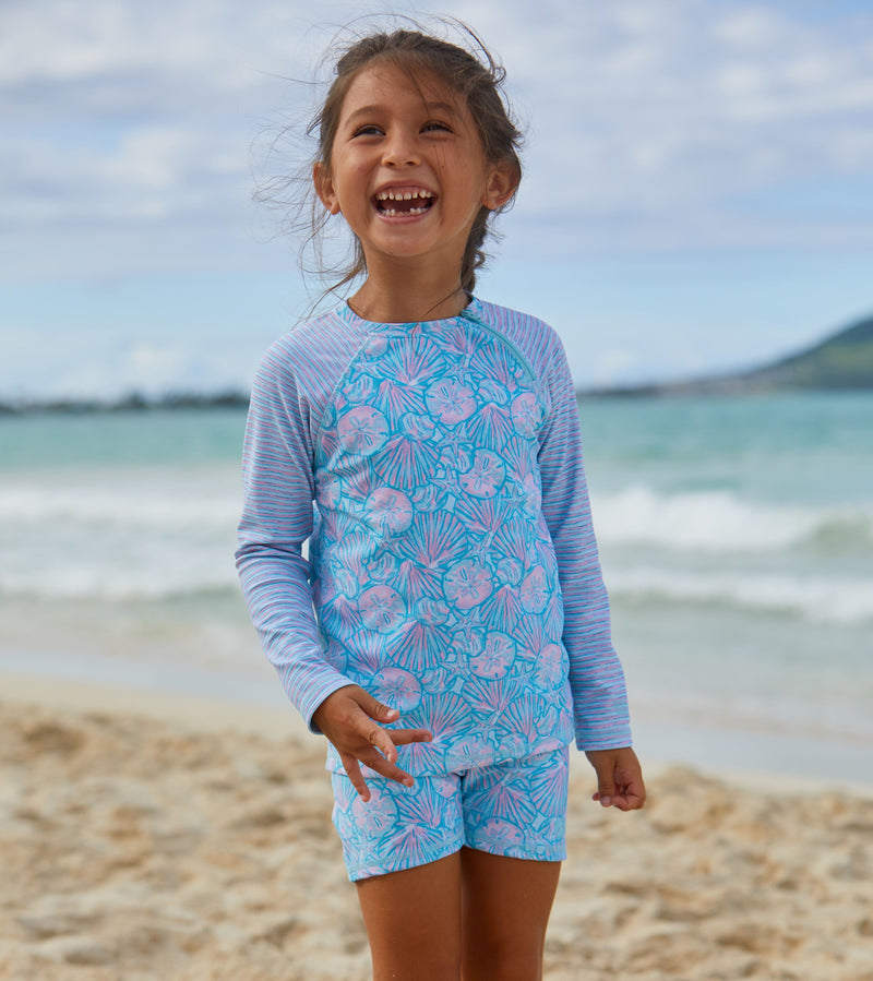 Girl in UV Skinz's girls long sleeve rash guard in candy shell stripes|candy-shells-stripes