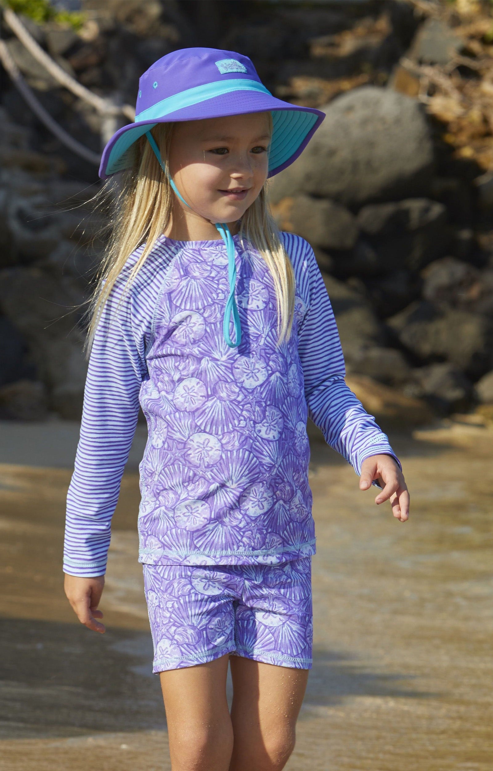 Little girl in UV Skinz's girls long sleeve rash guard in dreamy shells stripe|dreamy-shells-stripes