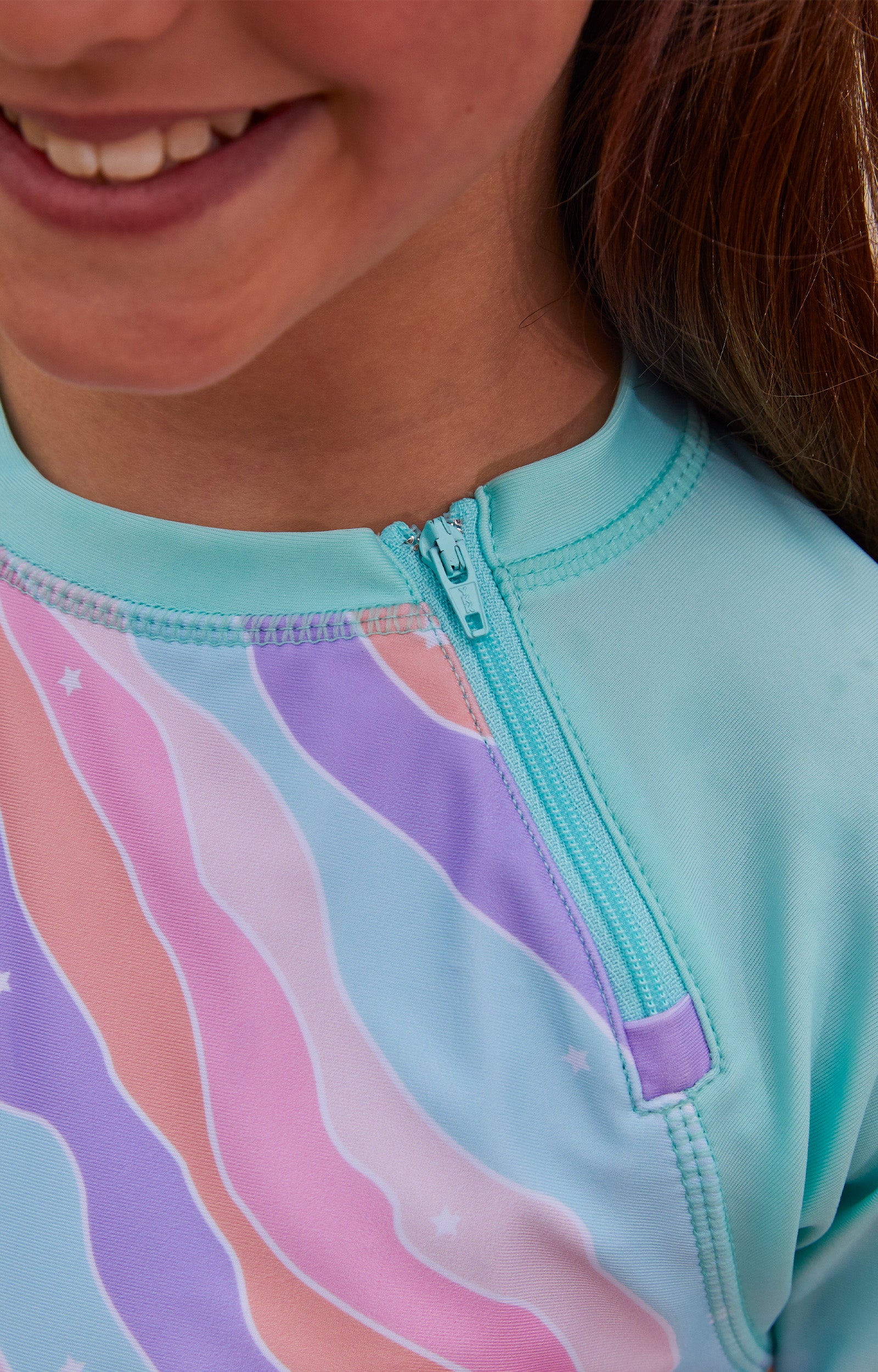 Close up of the zipper on the girl's zippy long sleeve sun and swim shirt|positive-energy