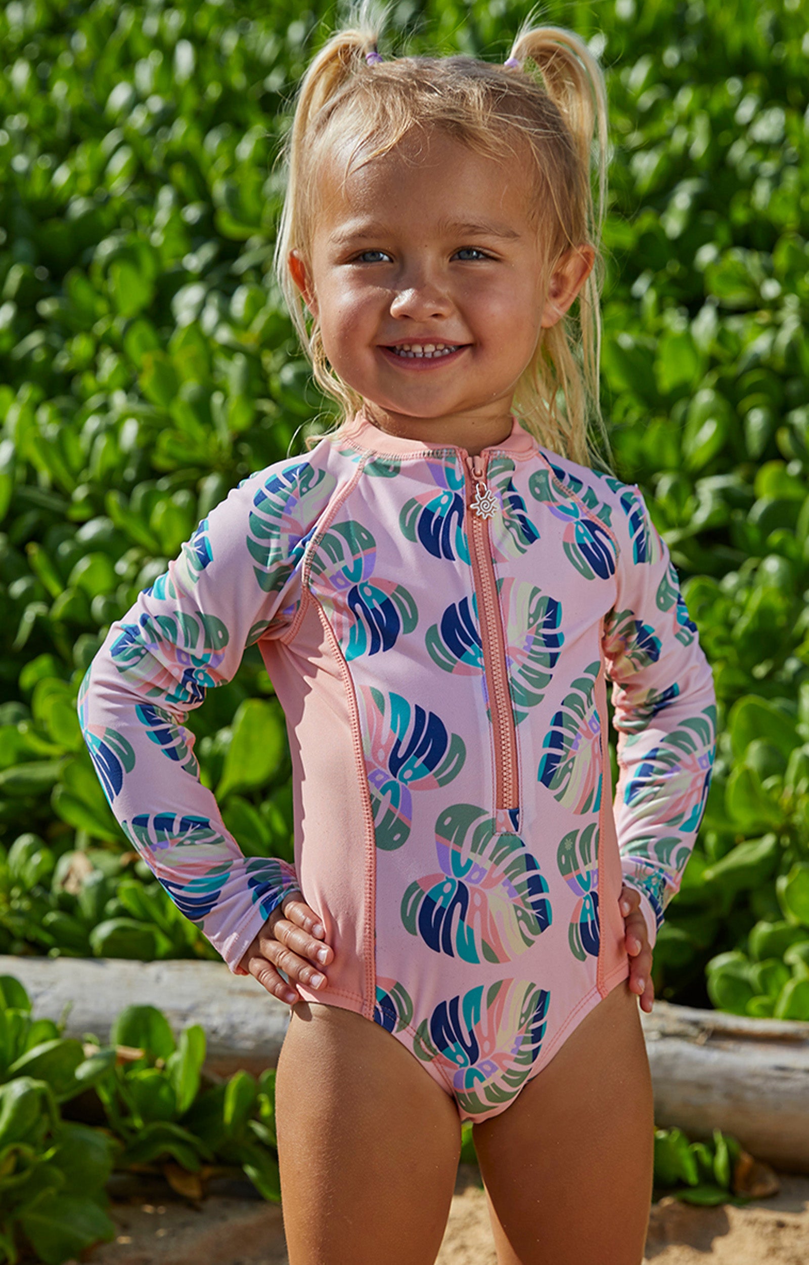 Little girl in UV Skinz's girl's long sleeve swimsuit in rainbow leaf|rainbow-leaf