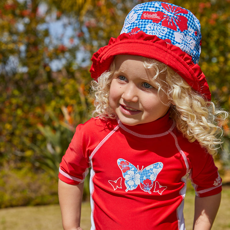 Little girl wearing UV Skinz's girls bucket hat in red americana gingham|red-americana-gingham
