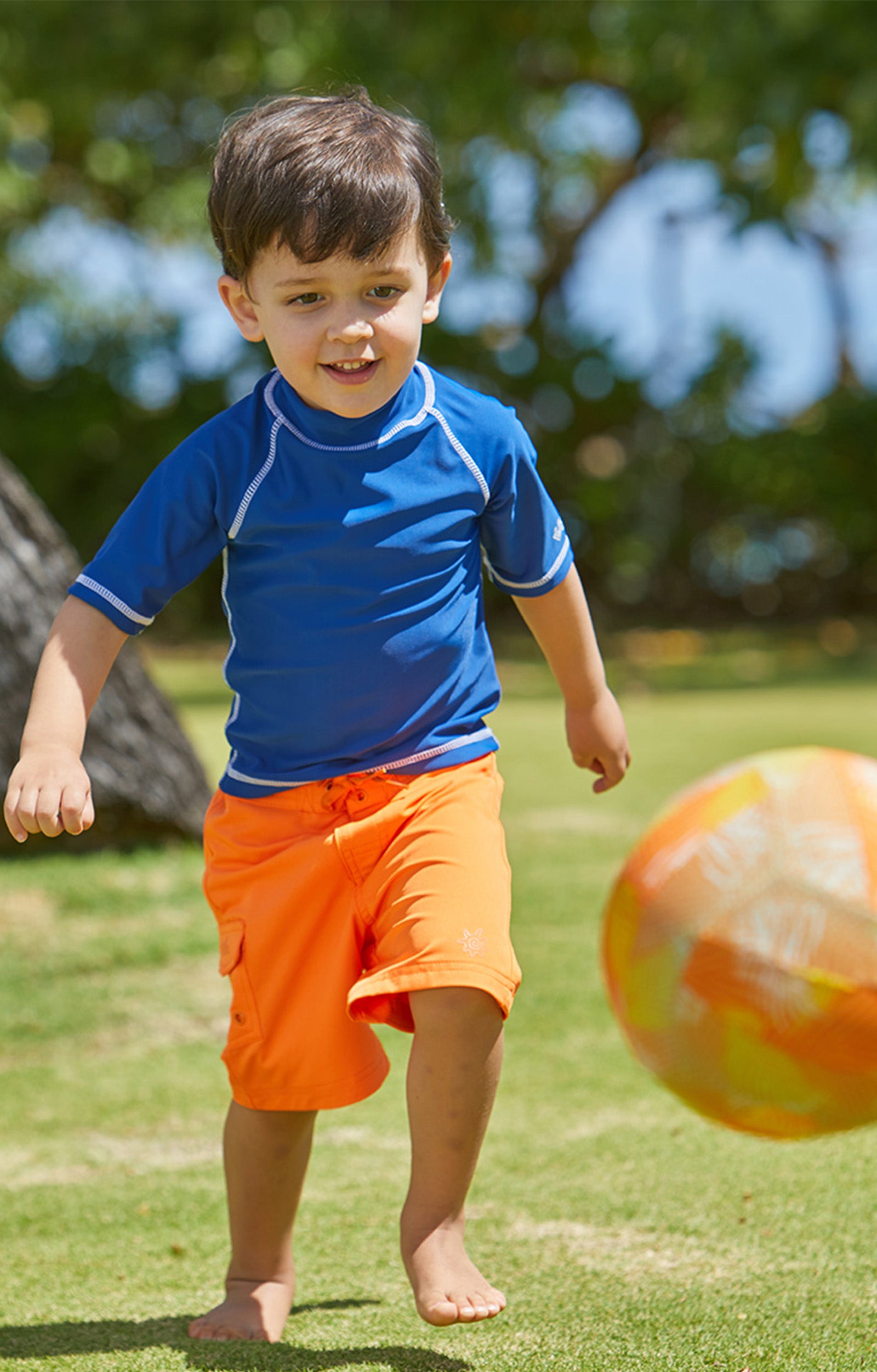 Young Boy Playing in the Sun in the Boy's Classic Board Shorts in Orange|orange
