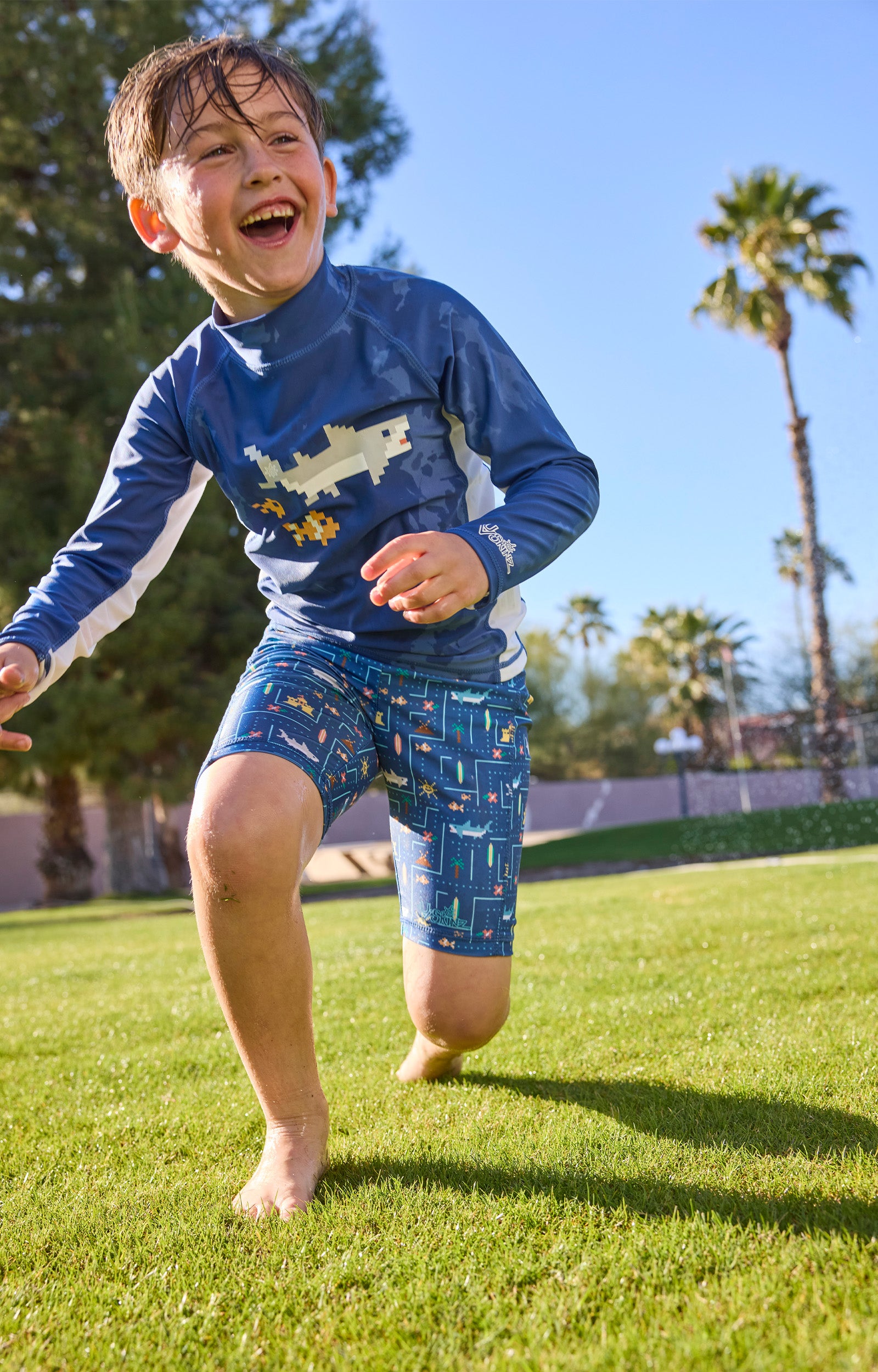 boy running in grass in swim and play jammerz|game-on