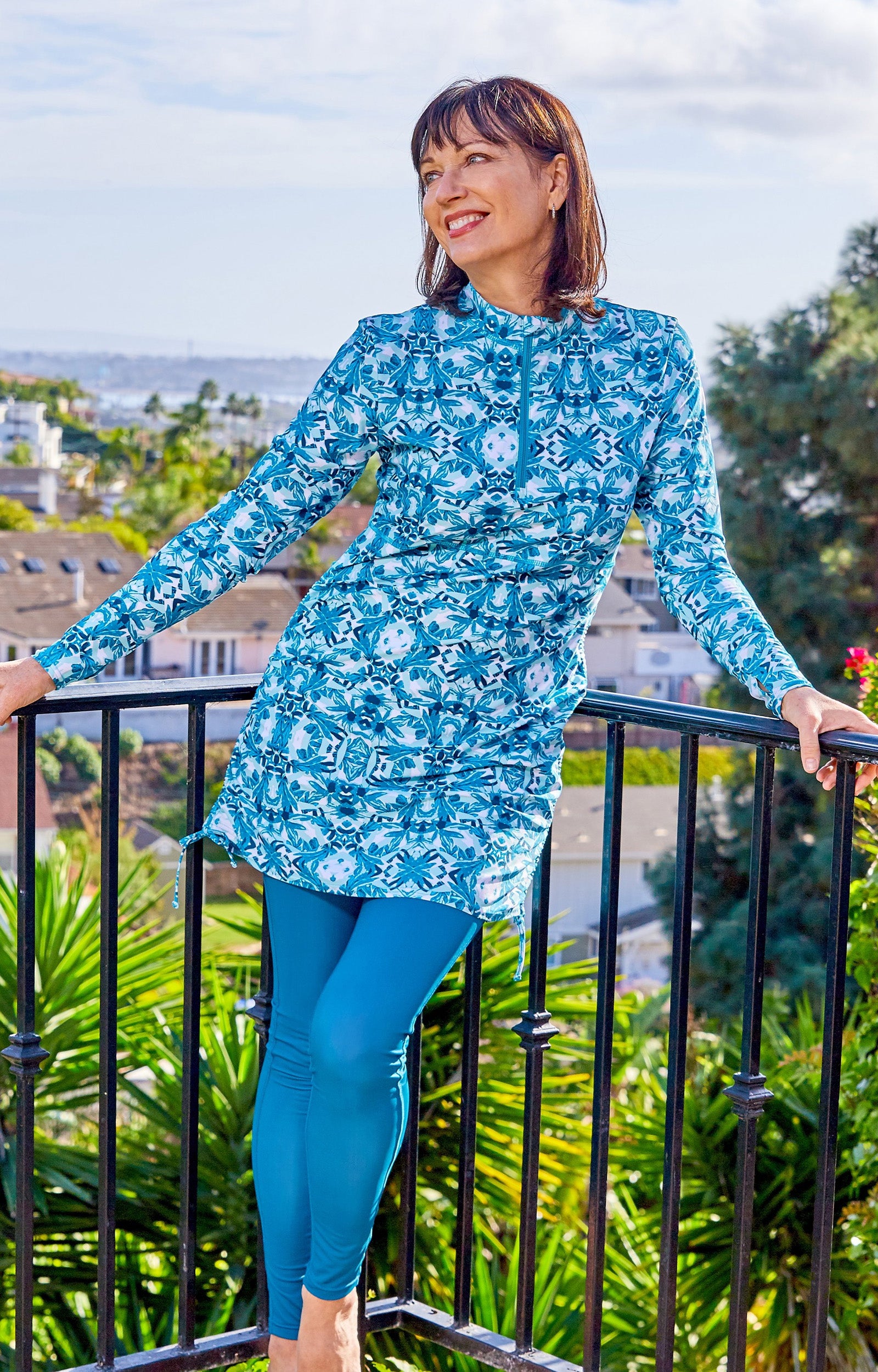 Woman in UV Skinz's Women's Active Sport Swim Tights in Dark Teal Outside on a Balcony|dark-teal