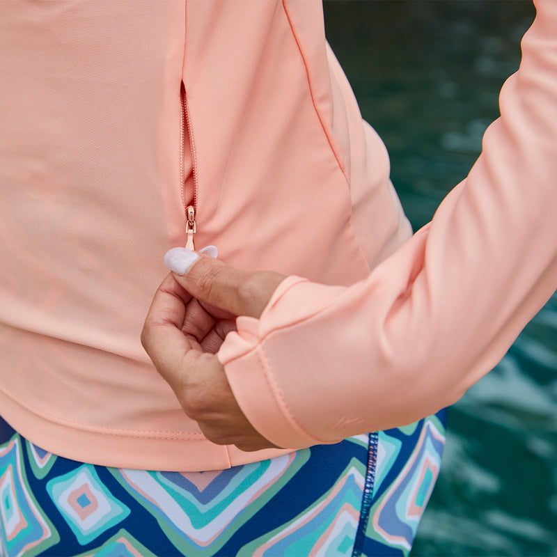 Close up of the zipper on the women's long sleeve crew swim shirt in apricot|apricot