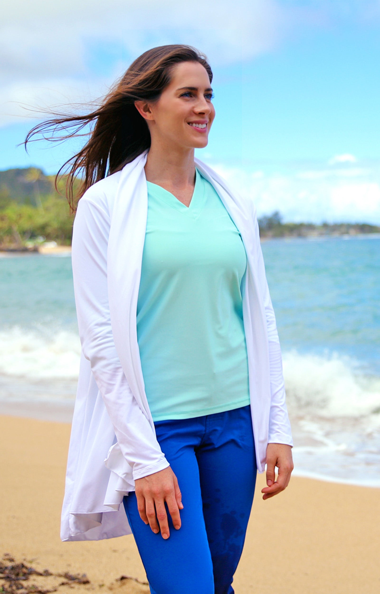 Woman wearing UV Skinz's women's hooded beach cover up in white|white
