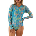 woman on sand on beach in long sleeve half zip swimsuit|caribbean-tropics