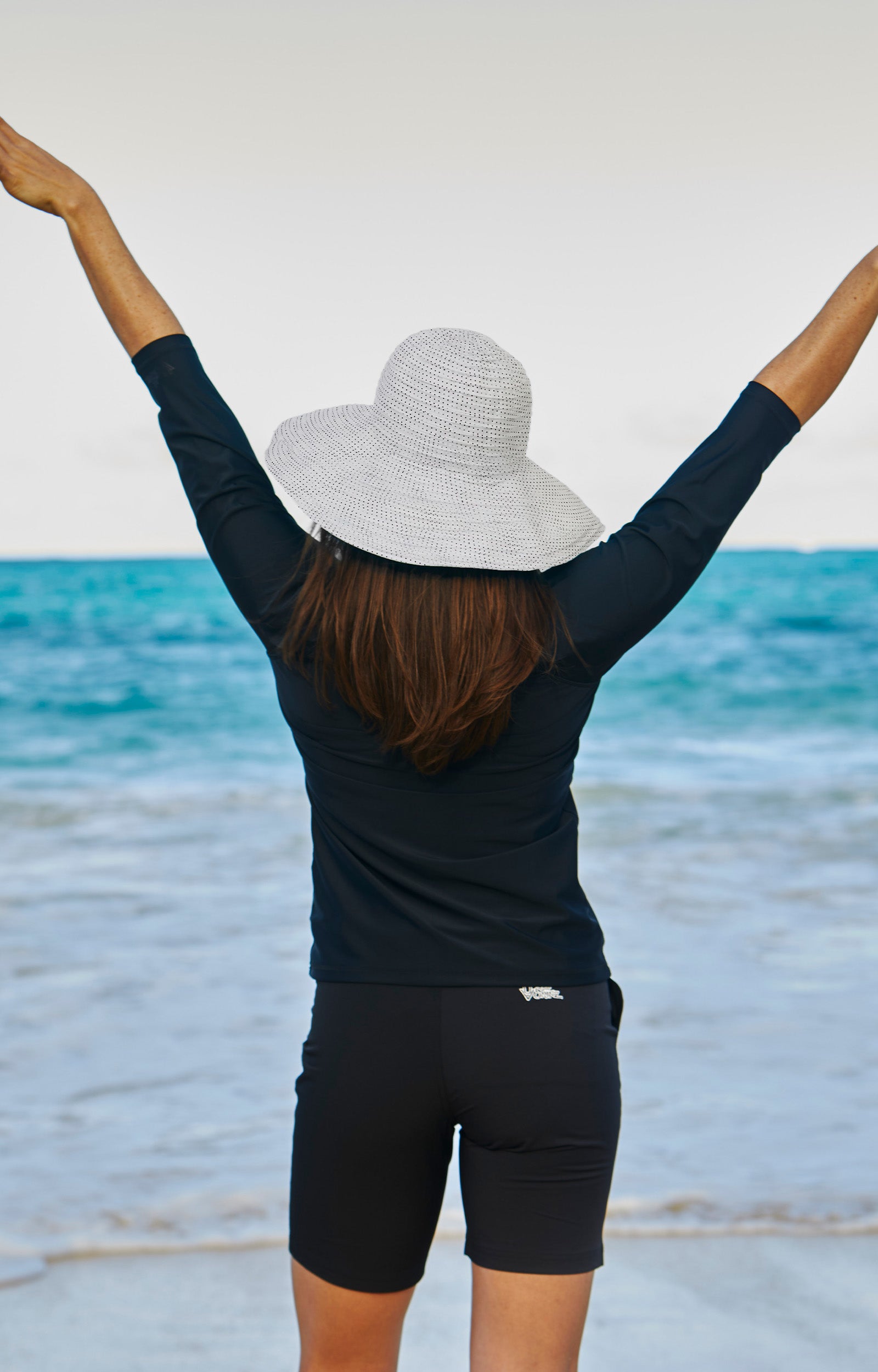 Woman in UV Skinz's wide brim sun hat|white