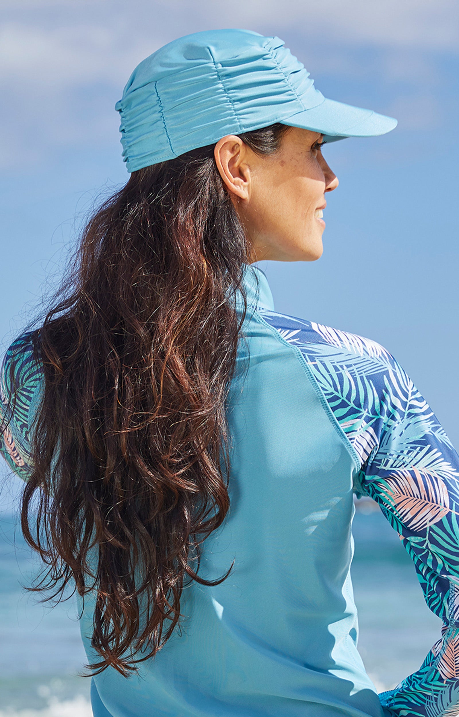 Woman wearing UV Skinz's women's swim cap in lagoon|lagoon
