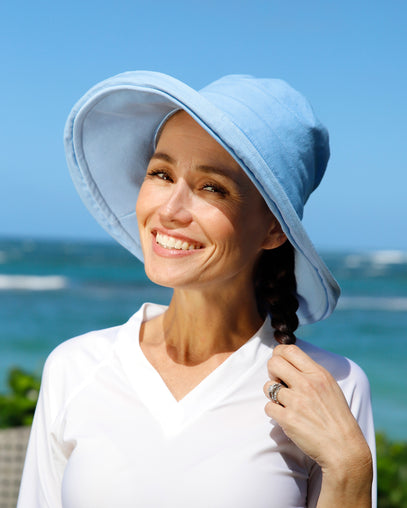 woman posing by the beach in wide brim sun hat|chambray-blue