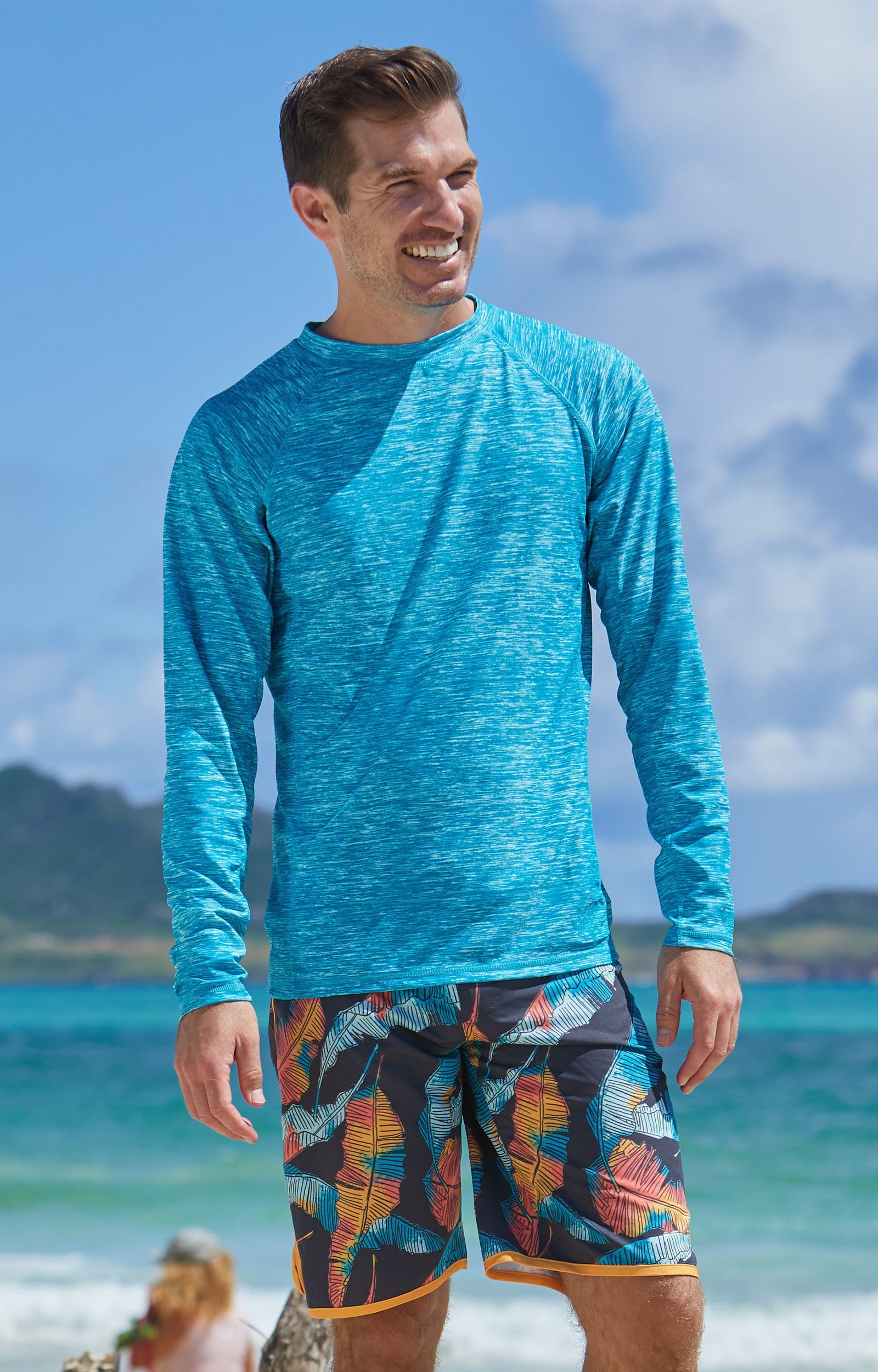 Man on the beach in UV Skinz's men's long sleeve crew swim shirt in caribbean jaspe|caribbean-jaspe