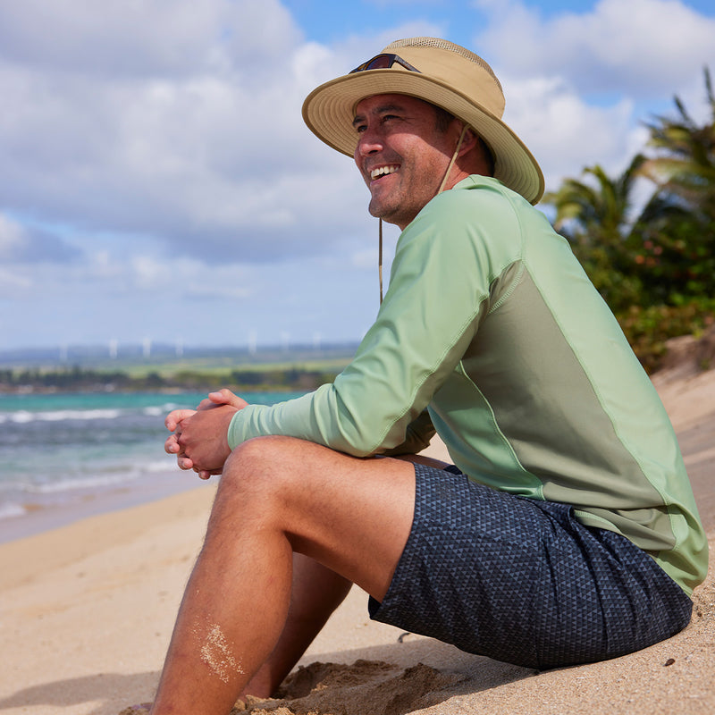 man sitting on sand on beach in men's long sleeve crew sun & swim shirt|sage-washed-olive
