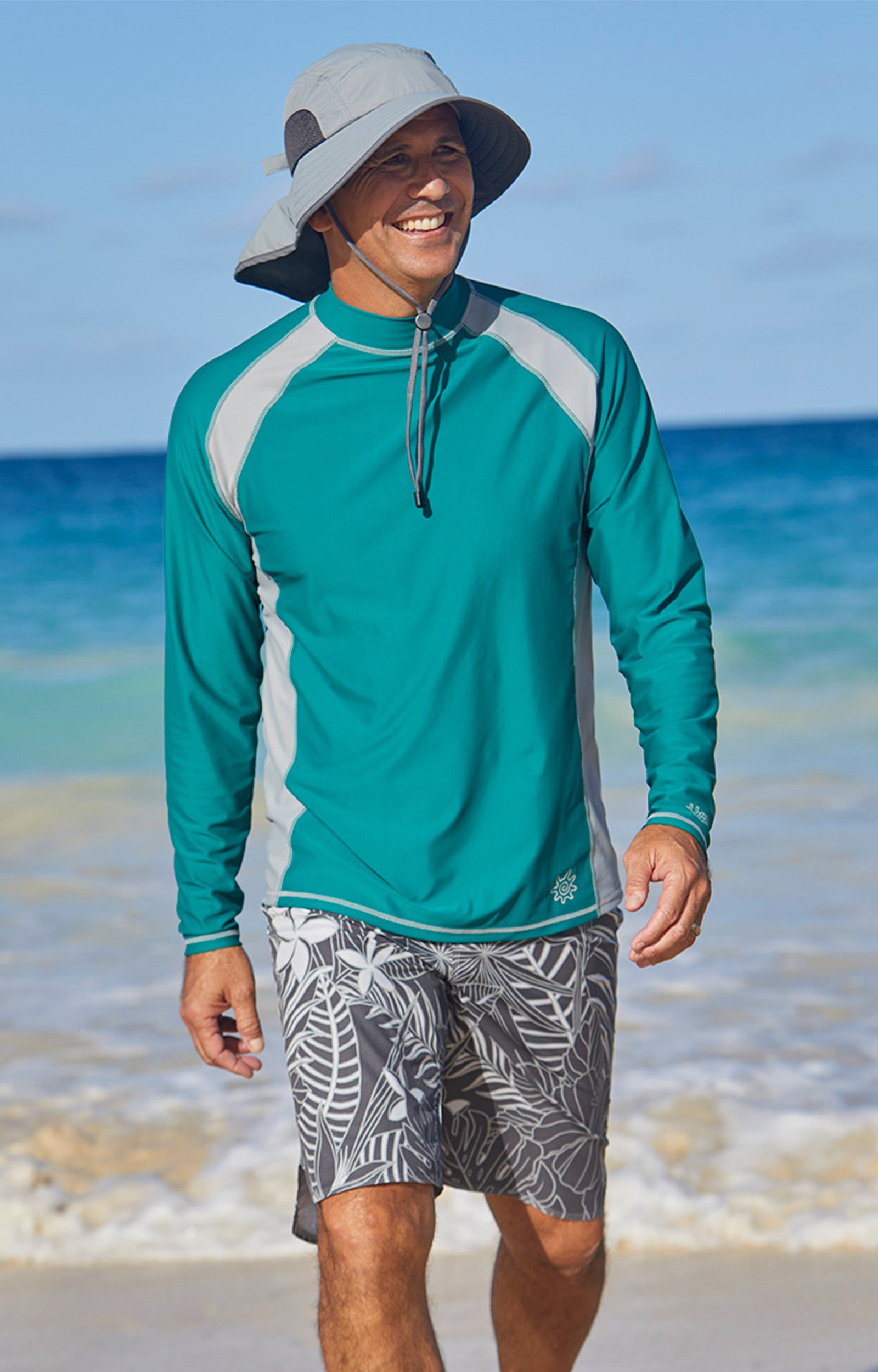 Man on the beach in UV Skinz's board shorts|charcoal-oasis