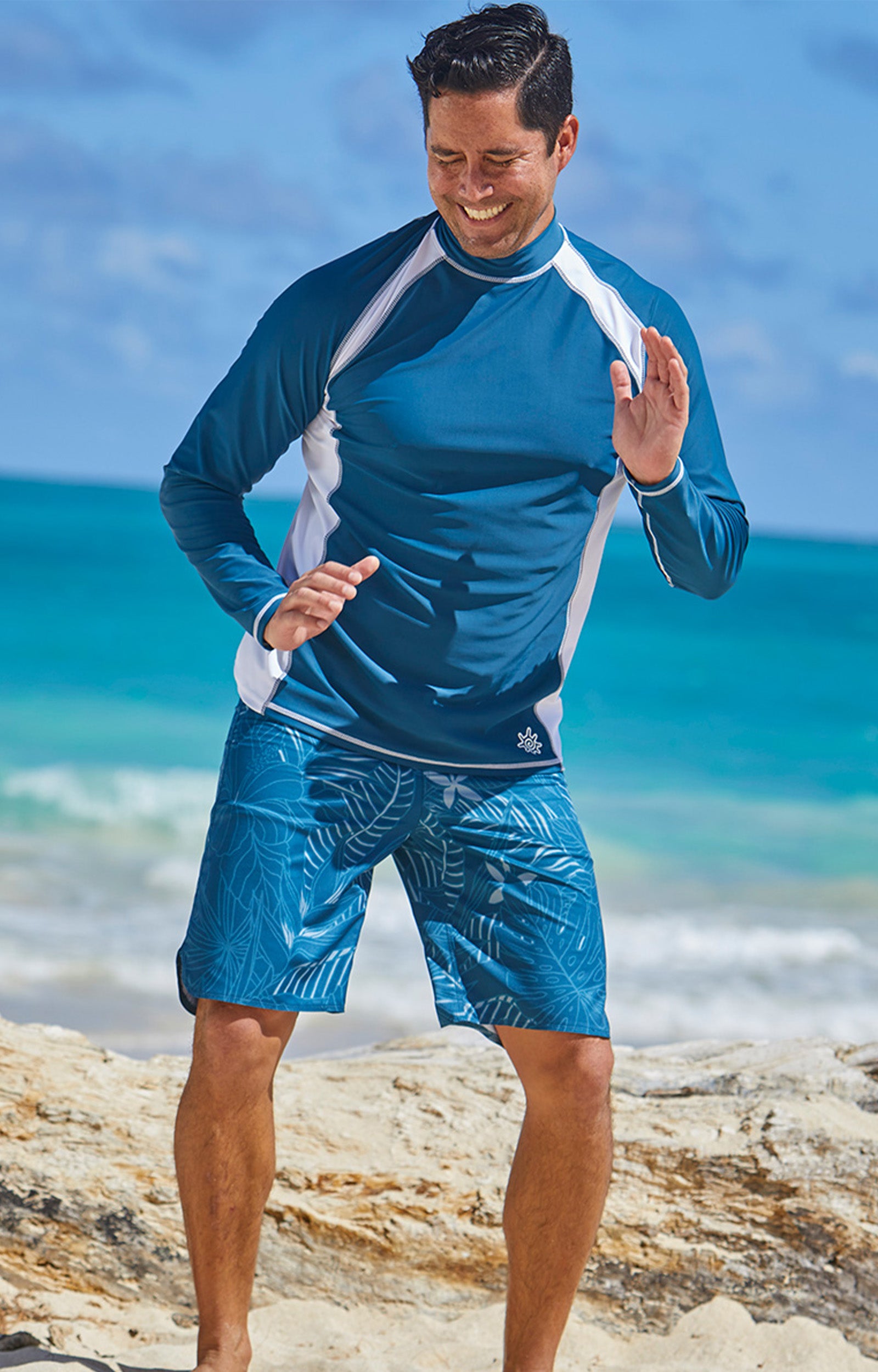 Man playing on the beach in UV Skinz's board shorts|midnight-oasis