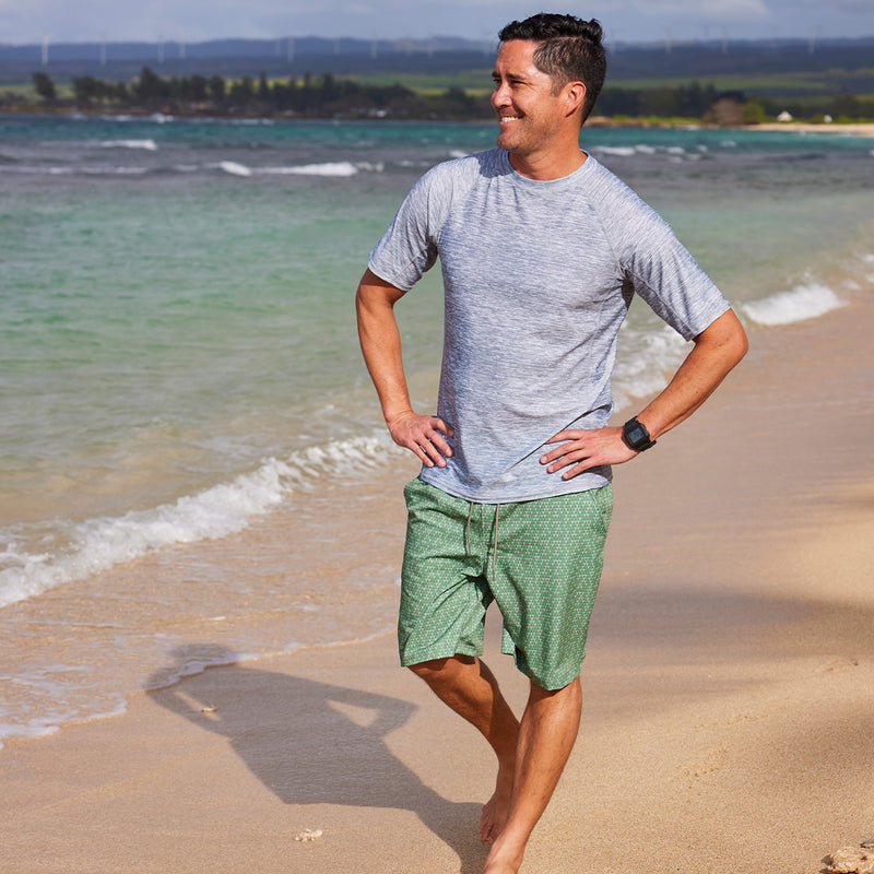 man walking on beach in waves in classic trunks|washed-olive-pyramid-geo