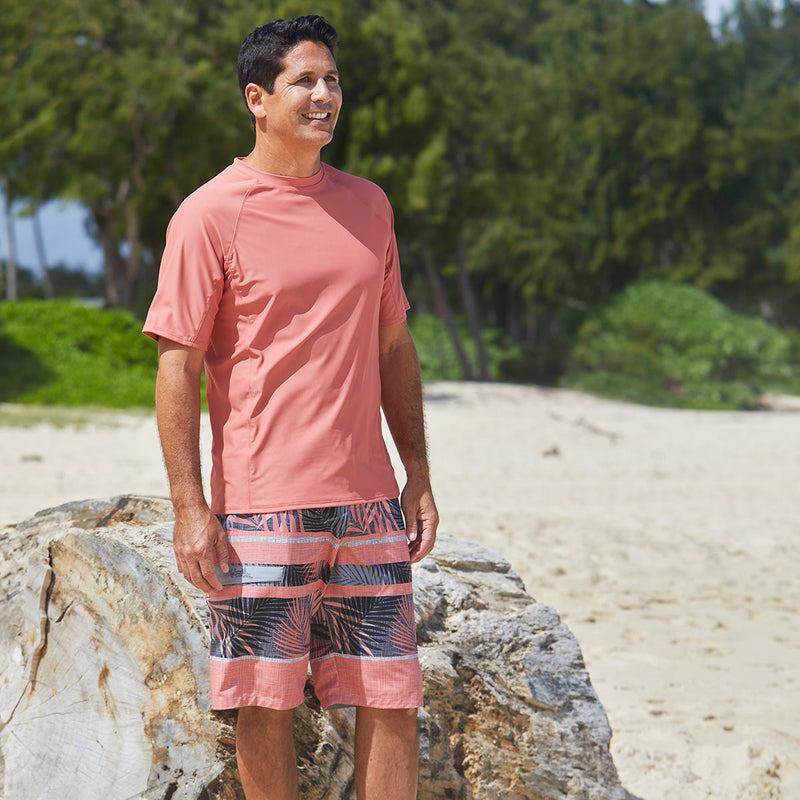 Man in UV Skinz's men's coastal board shorts|mint-watercolor-stripe