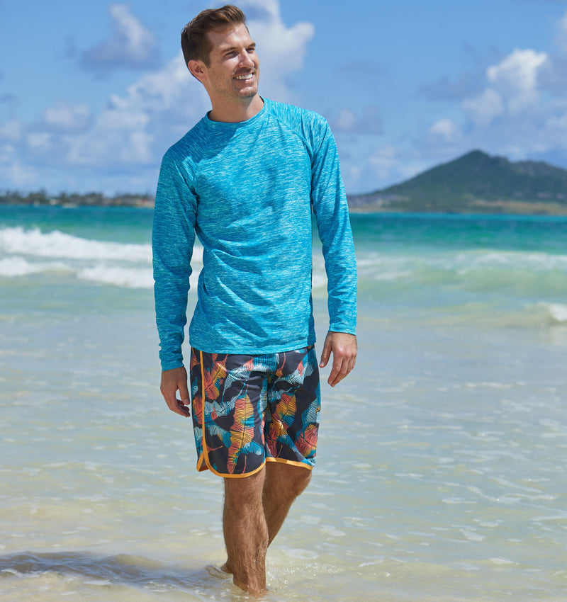 man on the beach in UV Skinz's men's retro board shorts in baja leaf|baja-leaf