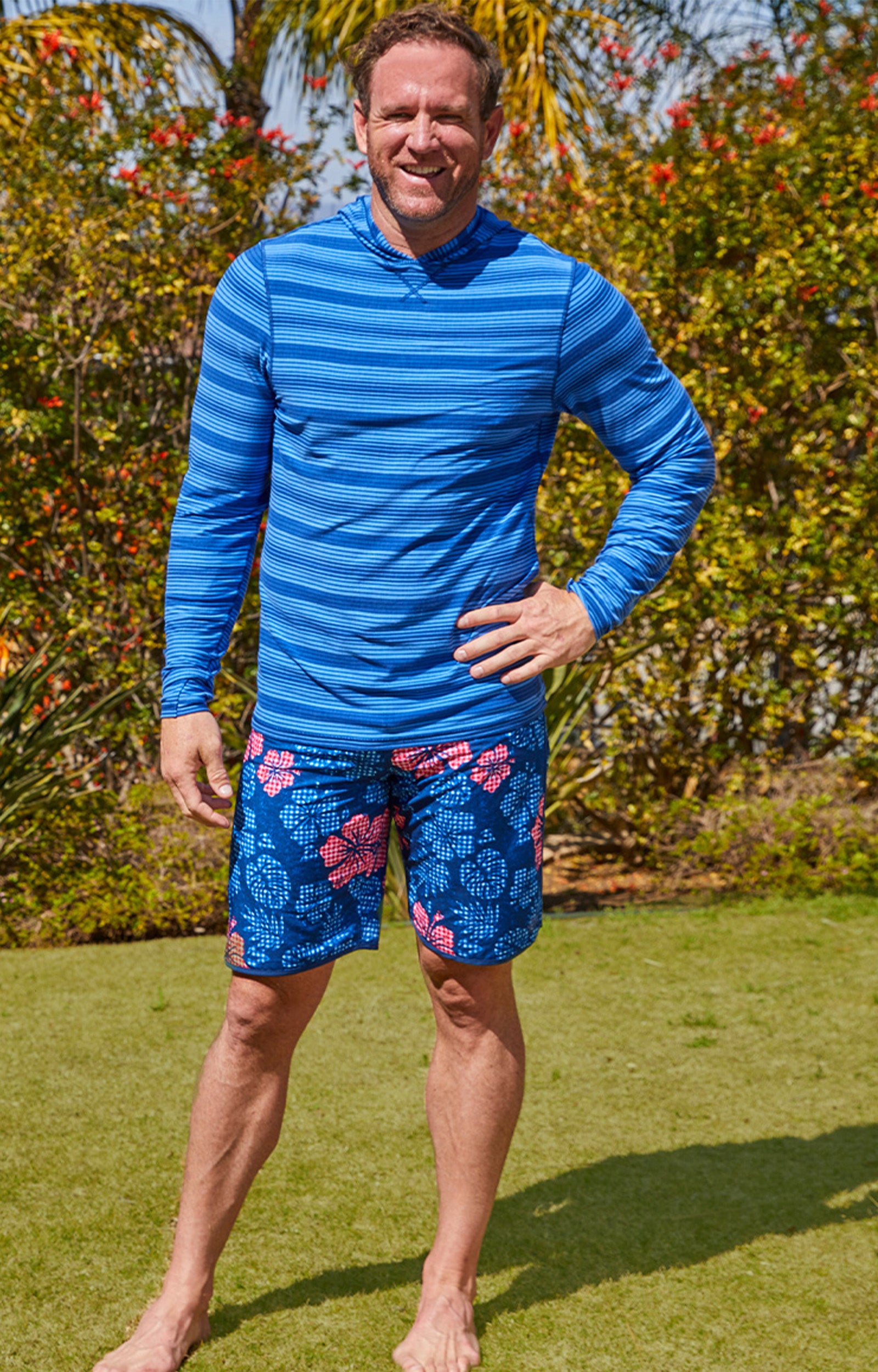 Man outside wearing UV Skinz's men's board shorts in dark navy hibiscus|dark-navy-hibiscus