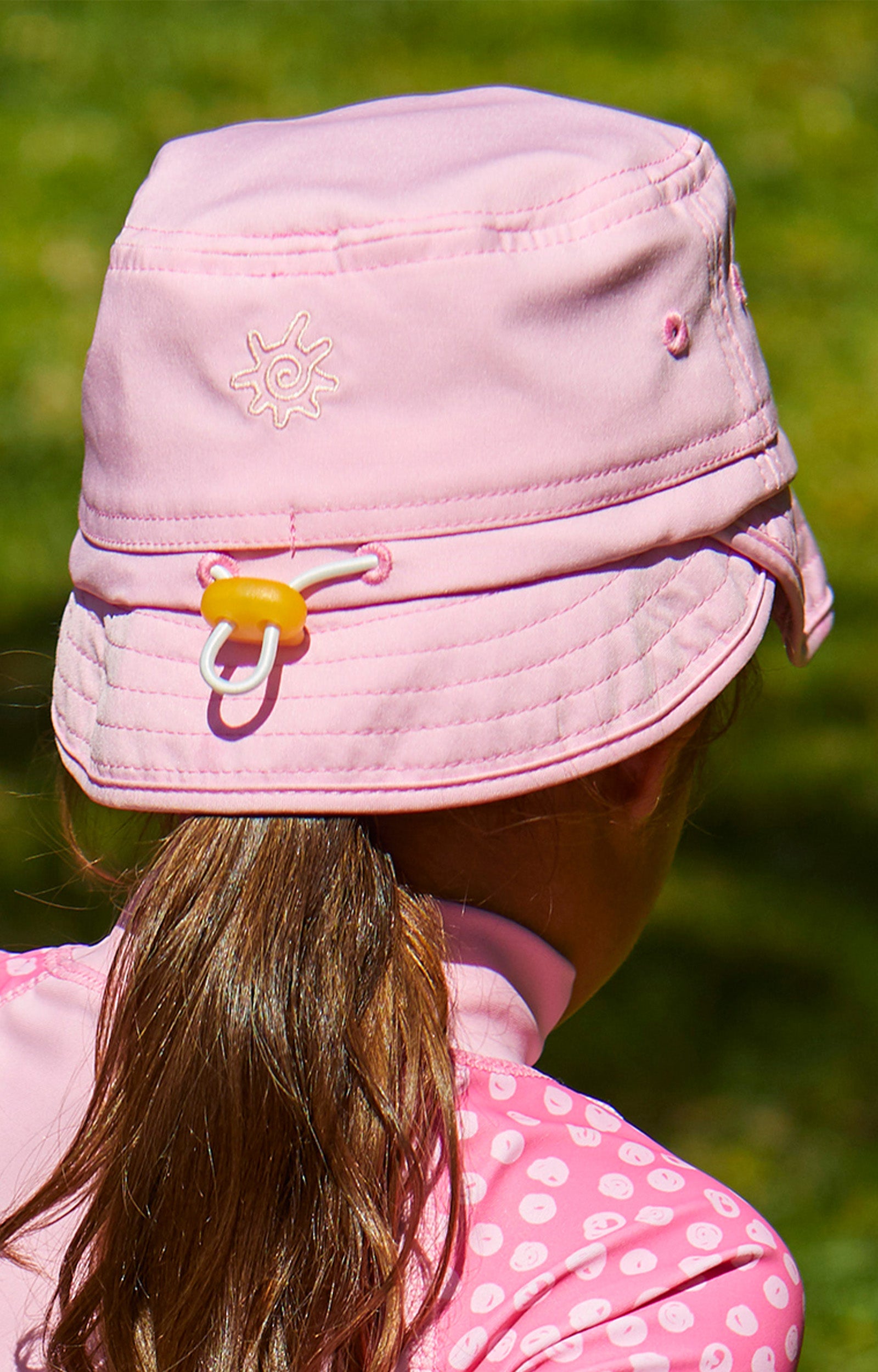 back view of the kid's adjustable flap sun hat in light pink|light-pink