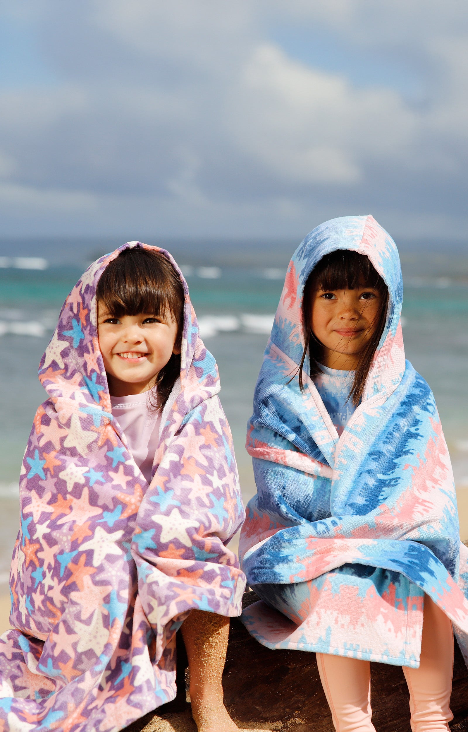 girls sitting on beach in kids hooded beach towel|sandcastle-dreams