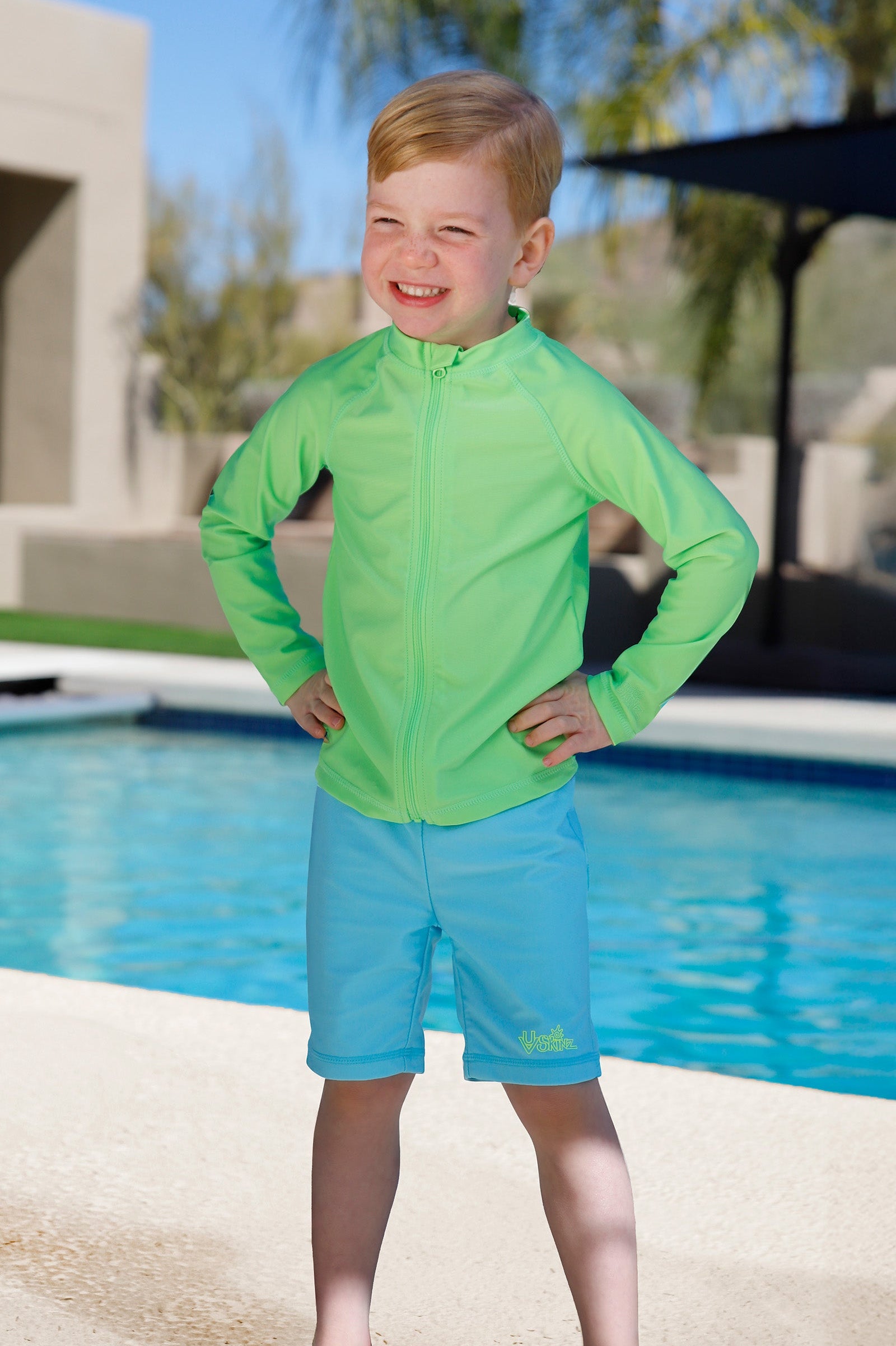 boy playing by pool wearing kids neon swim and play jammerz|neon-sky