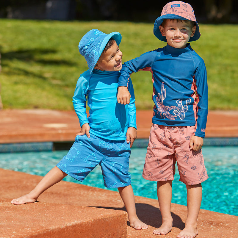 Boy's playing in UV Skinz's boys beach shorts in inky octopus|inky-octopus