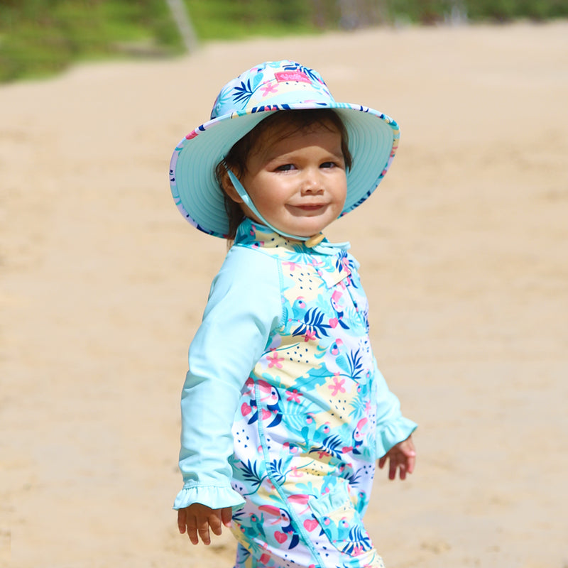 Little baby girl in UV Skinz's baby girl's swim hat in beach glass toucan|beach-glass-toucan