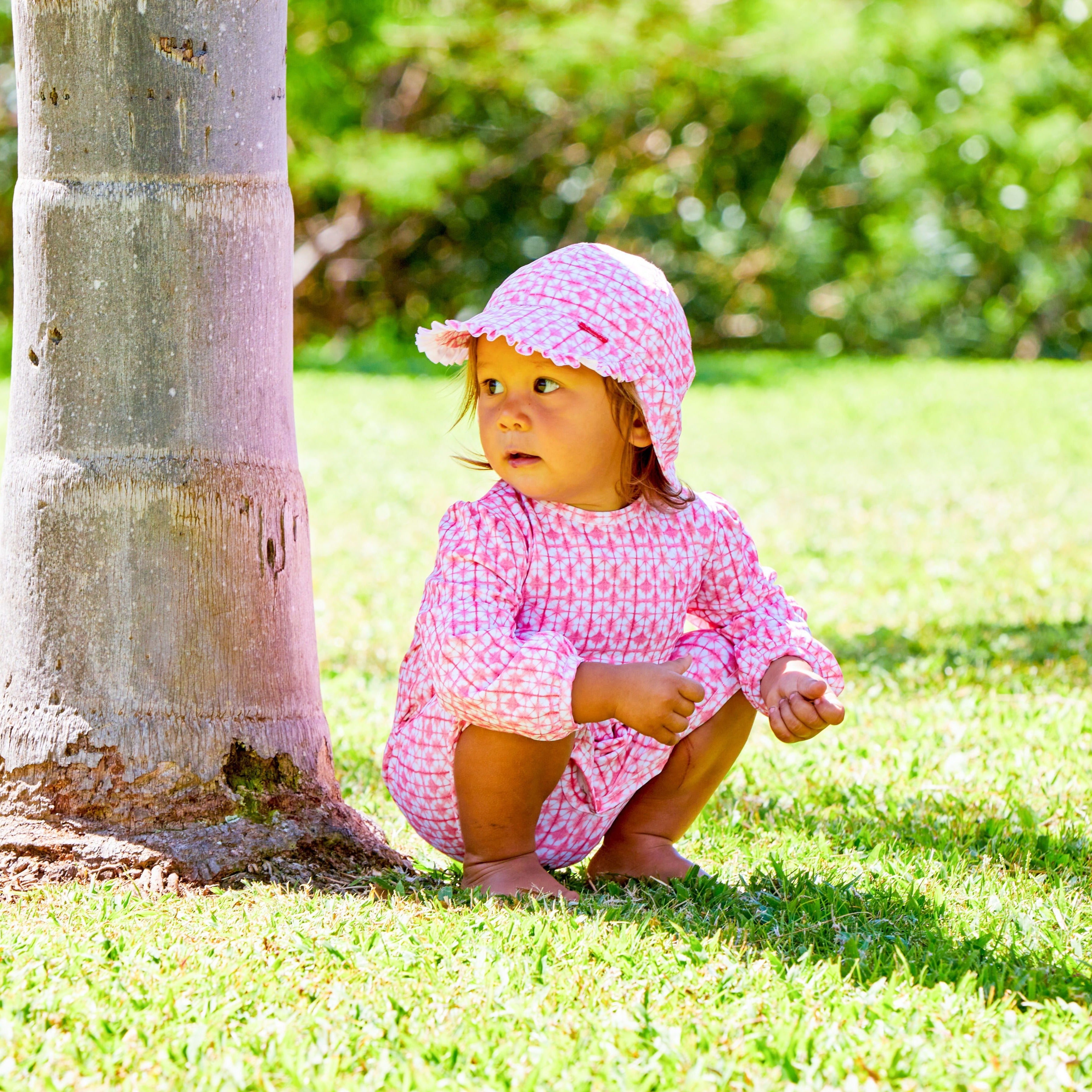 Little girl in UV Skinz's baby girls swim flap hat|beach-glass-floral
