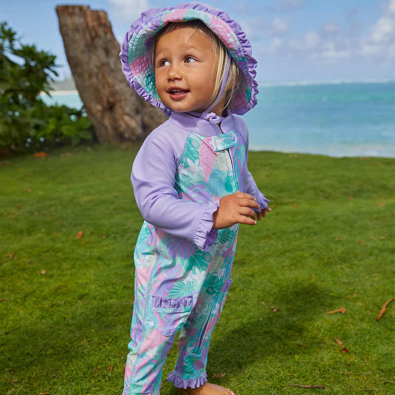 Little girl wearing UV Skinz's baby girl's reversible sun hat in hidden pineapples|hidden-pineapples