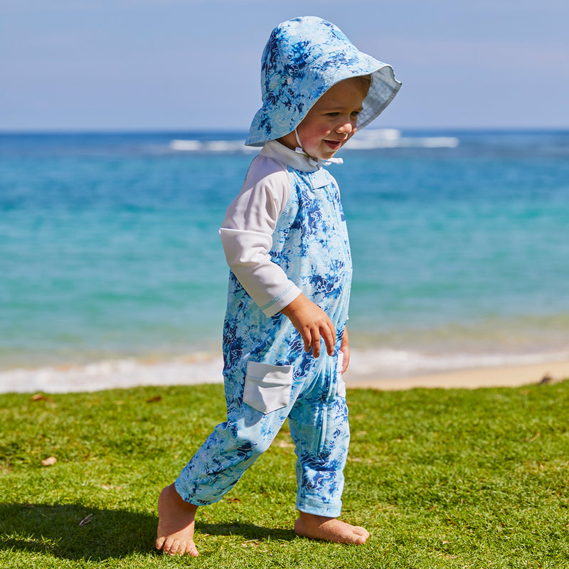 Little boy at the beach in UV Skinz's boy's long-sleeve swimsuit in sea friends|sea-friends