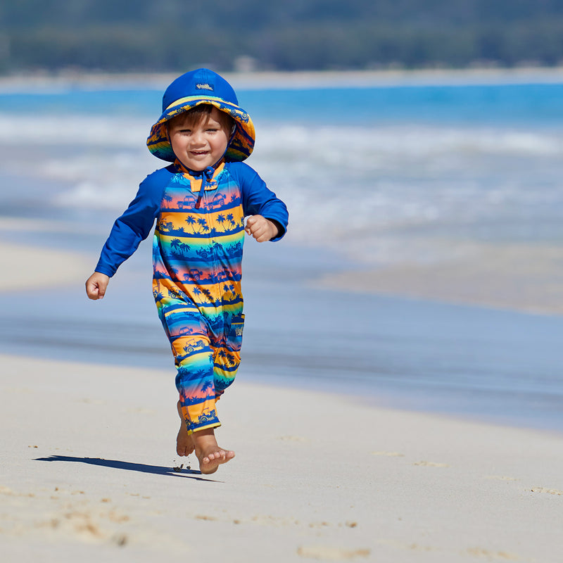 baby boy walking on the beach in the baby boy's long-sleeve swimsuit in sunset safari ride|sunset-safari-ride
