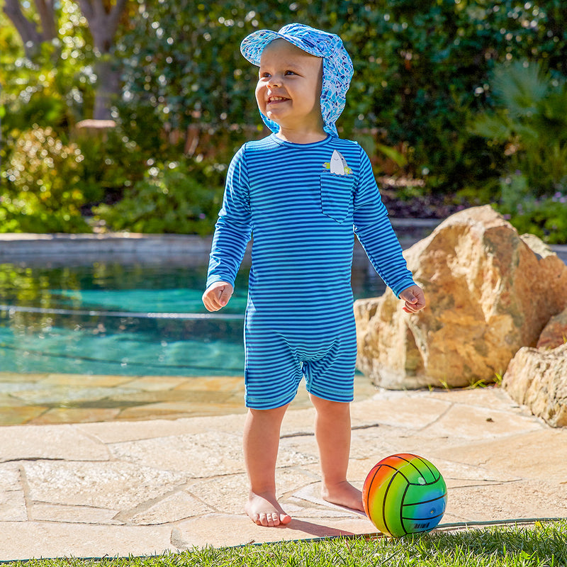 Baby boy playing in UV Skinz's baby boy's UV onesie in aqua shark|aqua-shark